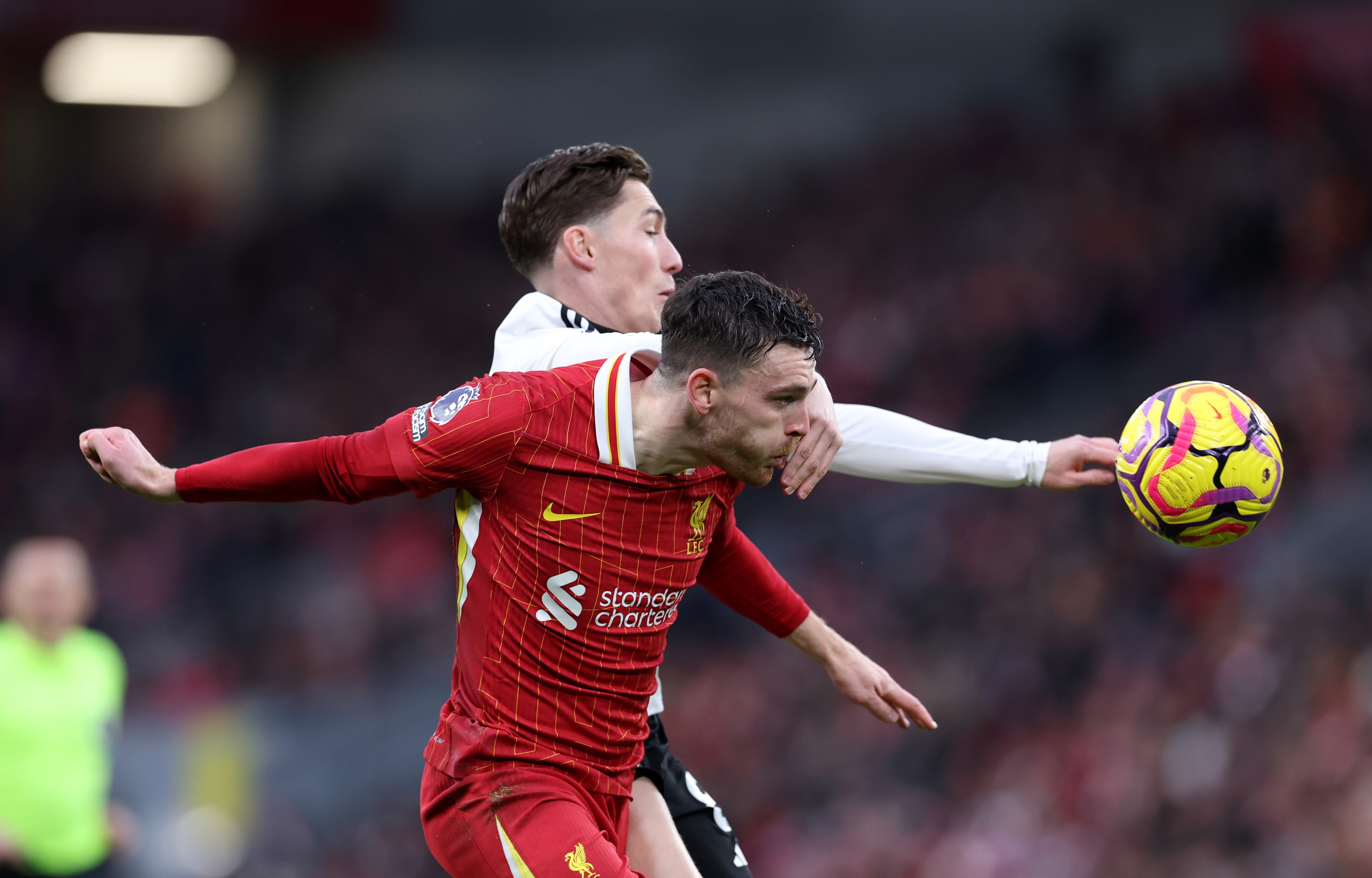 Andy Robertson and Harry Wilson compete for the ball at Anfield.