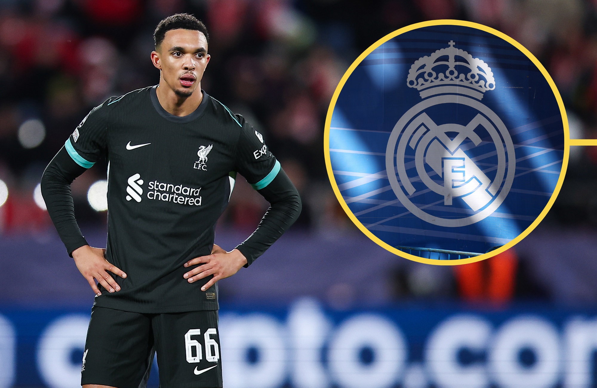Trent Alexander-Arnold stands with his hands on his hips looking at Real Madrid club badge.