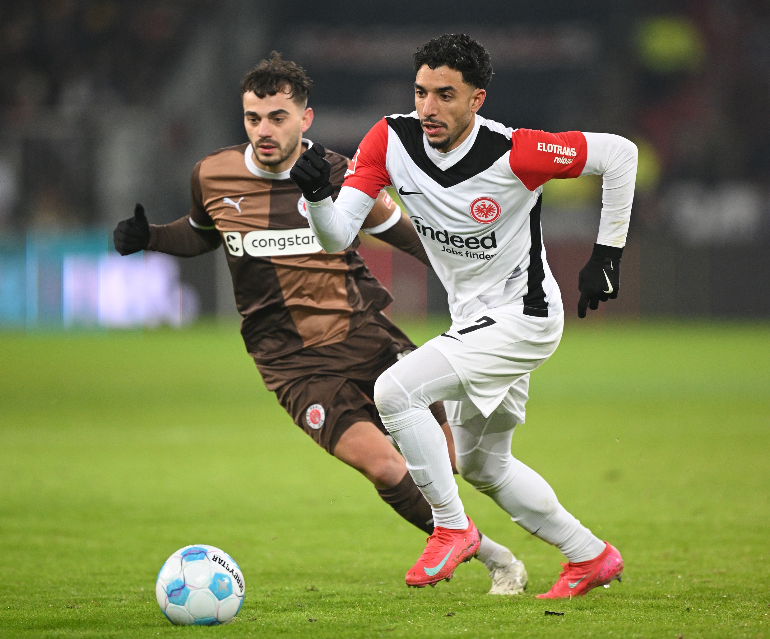 Omar Marmoush dribbles with the ball under pressure.