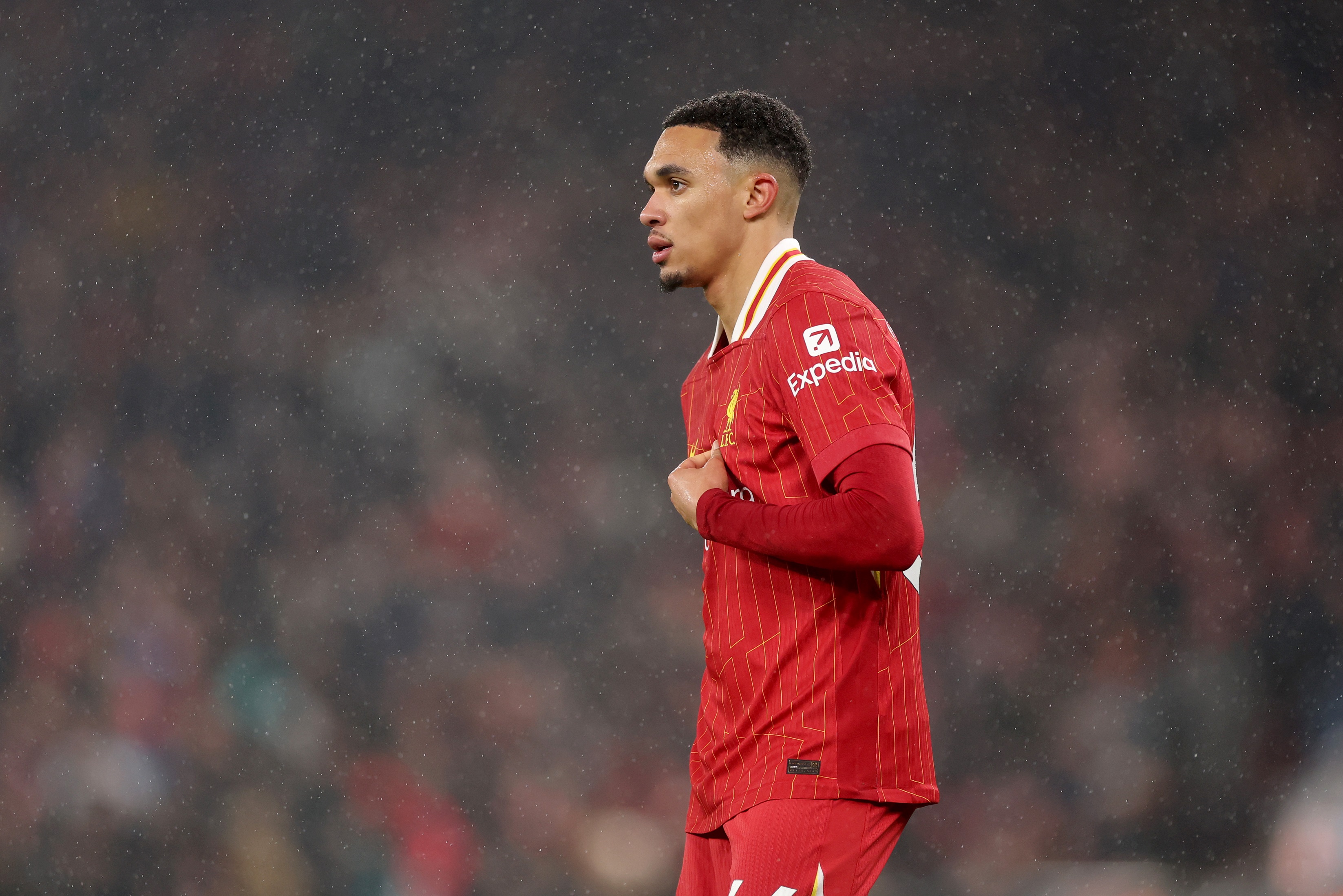 Trent Alexander-Arnold grips his shirt at Anfield during match against Manchester United.