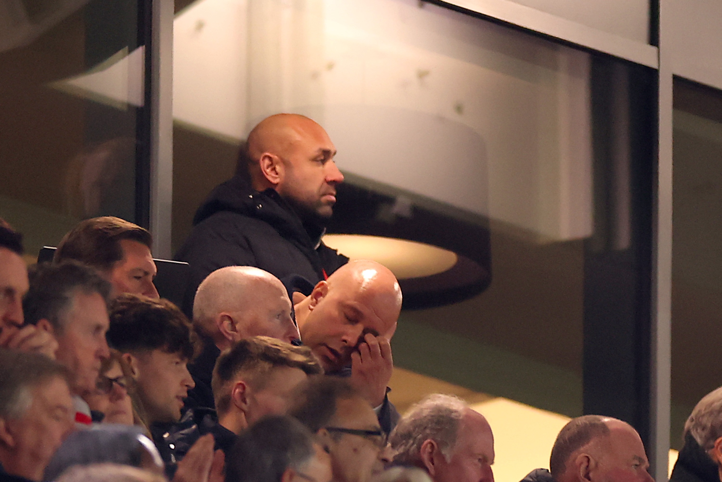 Arne Slot touches his eye in the stands at Anfield.
