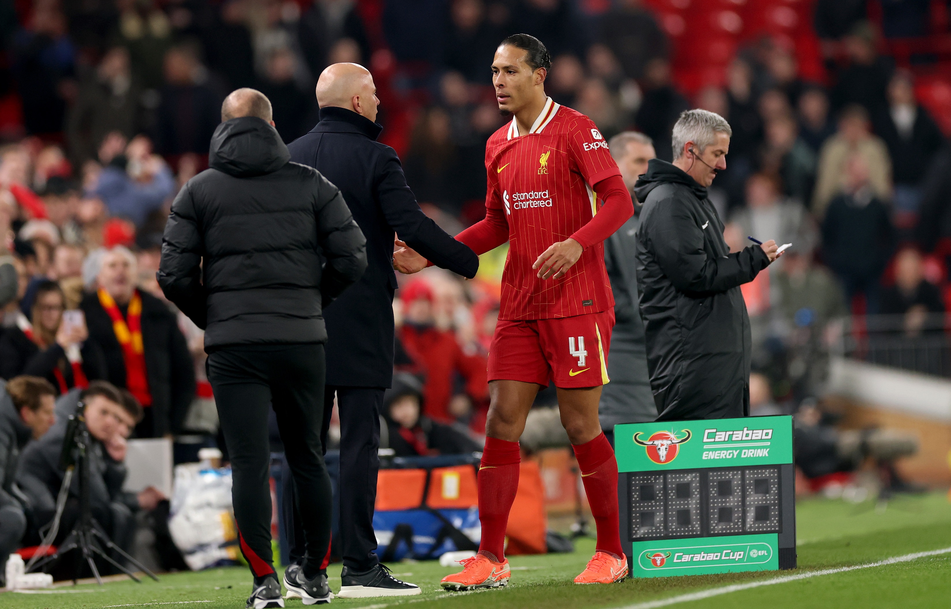 Virgil van Dijk shakes hands with Arne Slot on Anfield touchline.