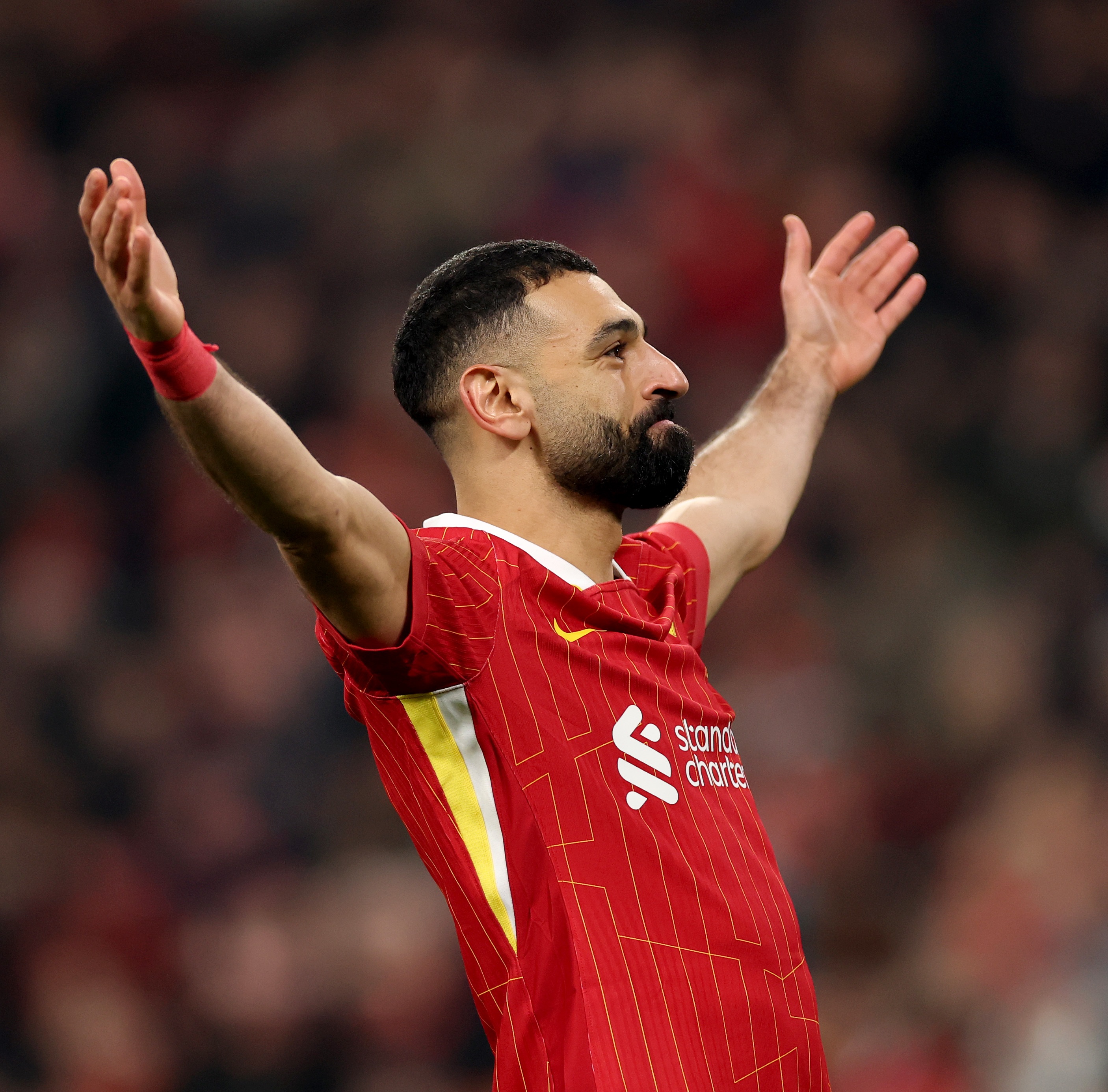 Mo Salah celebrates in front of Liverpool fans.