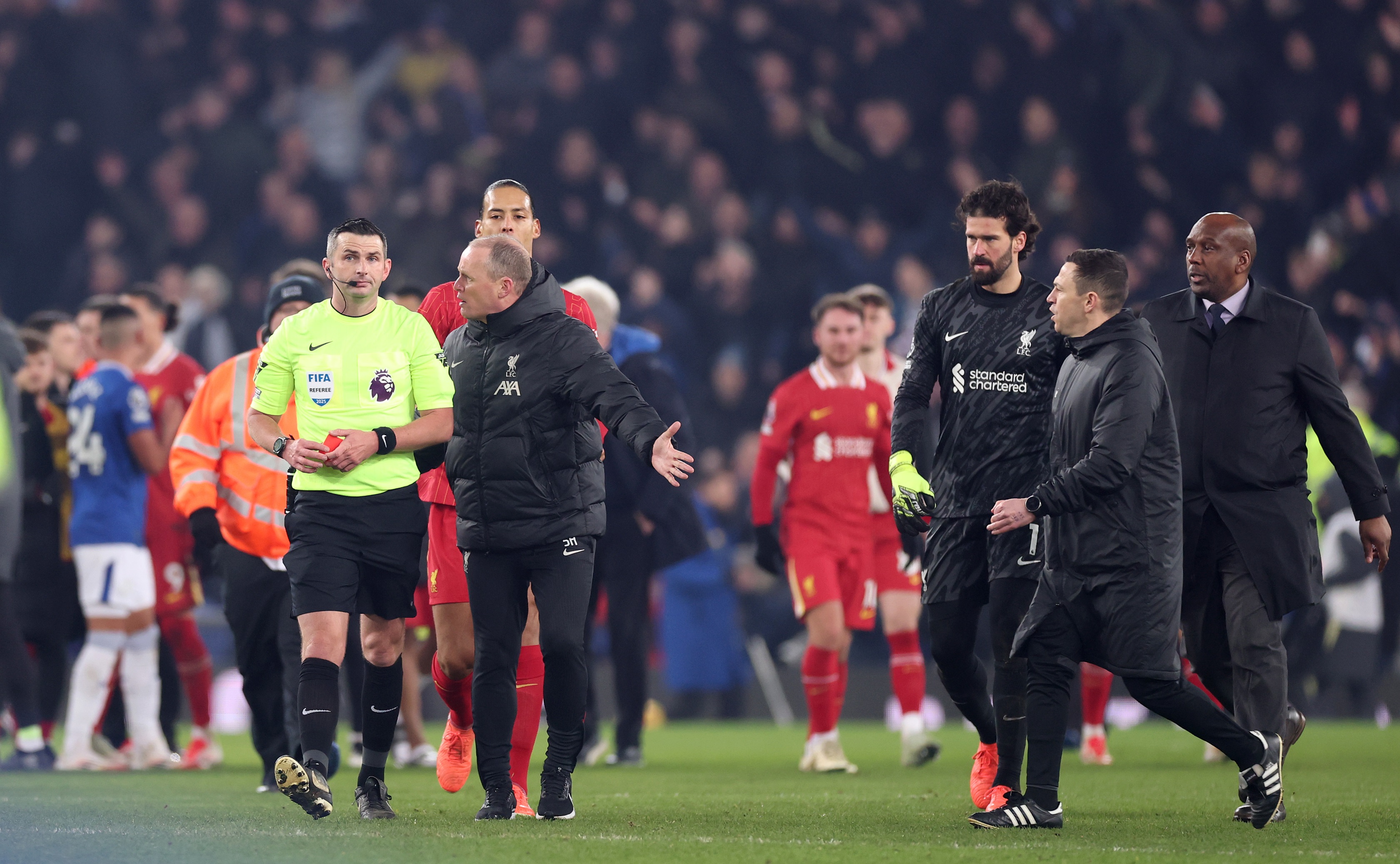 Liverpool assistant coach Sipke Hulshoff confronts Michael Oliver at Goodison Park.
