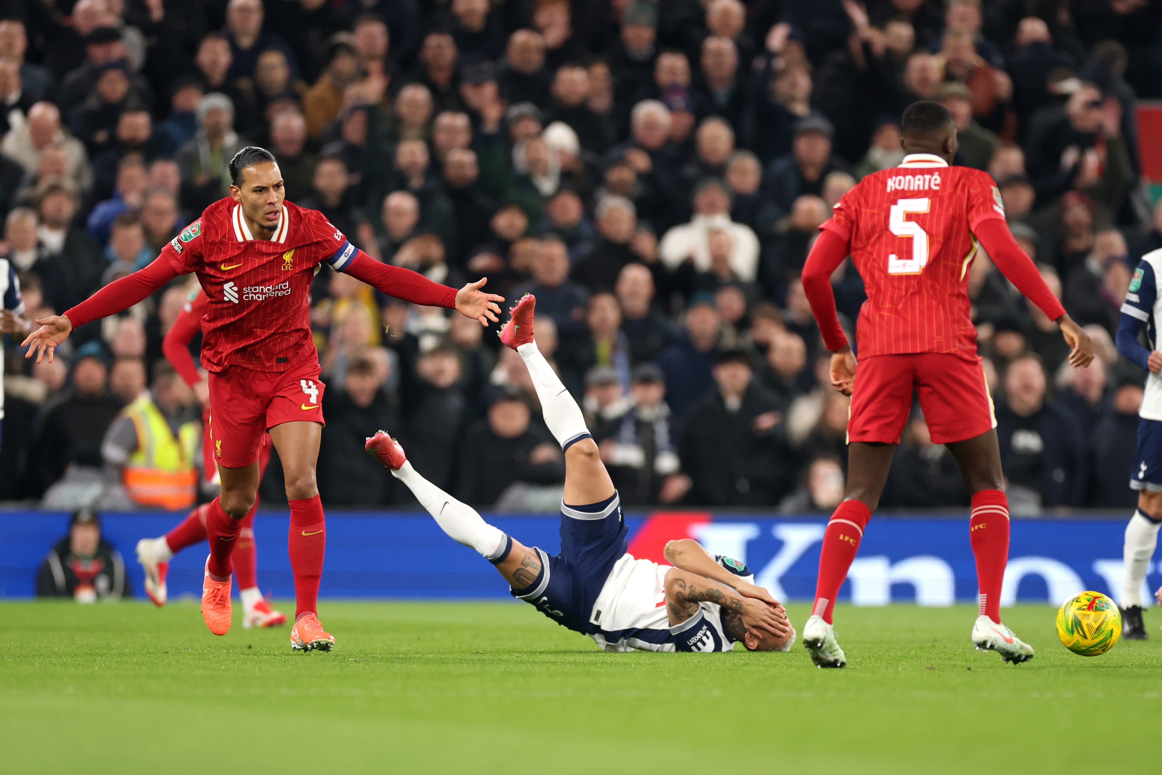 Virgil van Dijk holds out his arms after Richarlison falls to the ground.