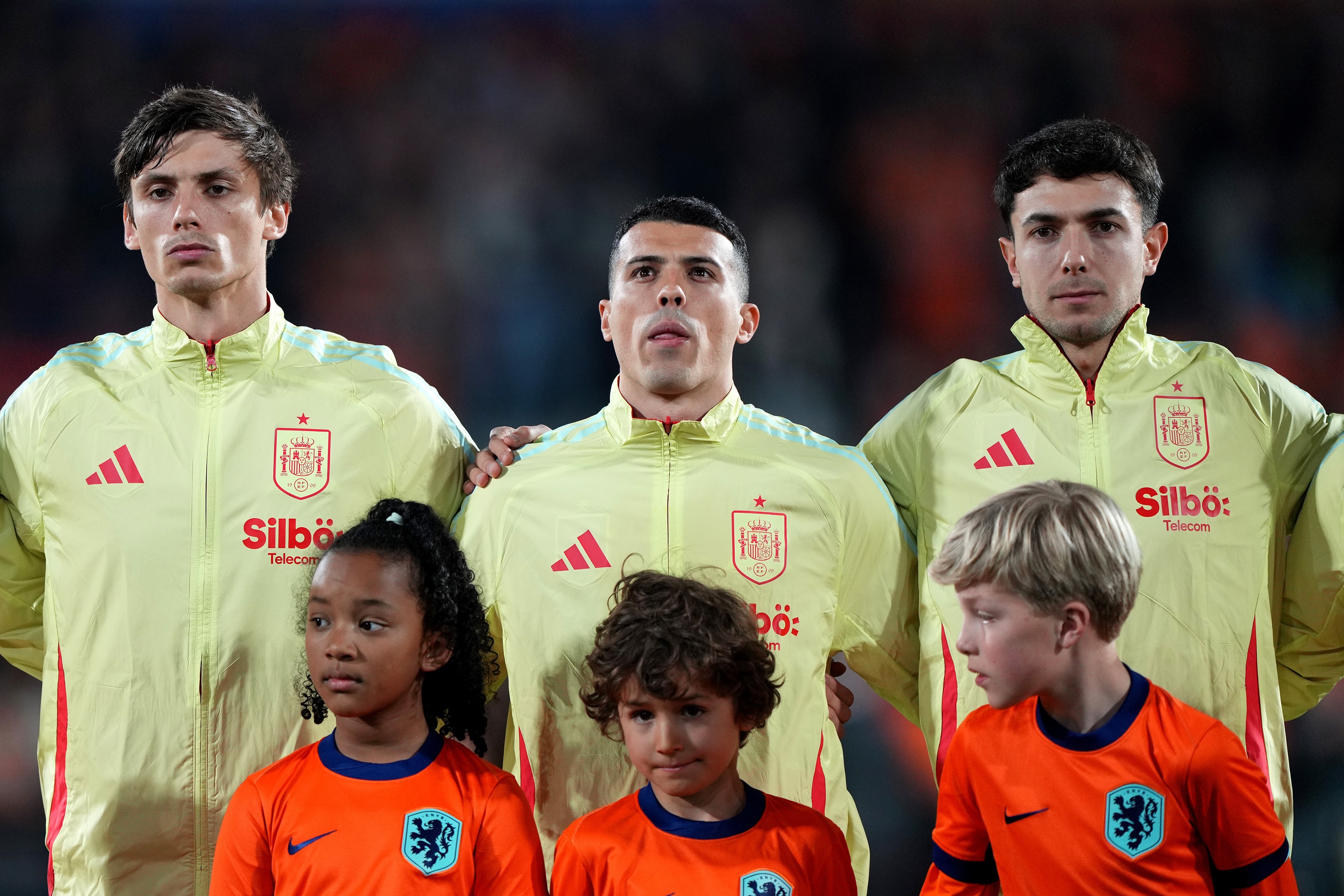 Martin Zubimendi puts his hand on Pedro Porro's shoulder as Spain players line up.
