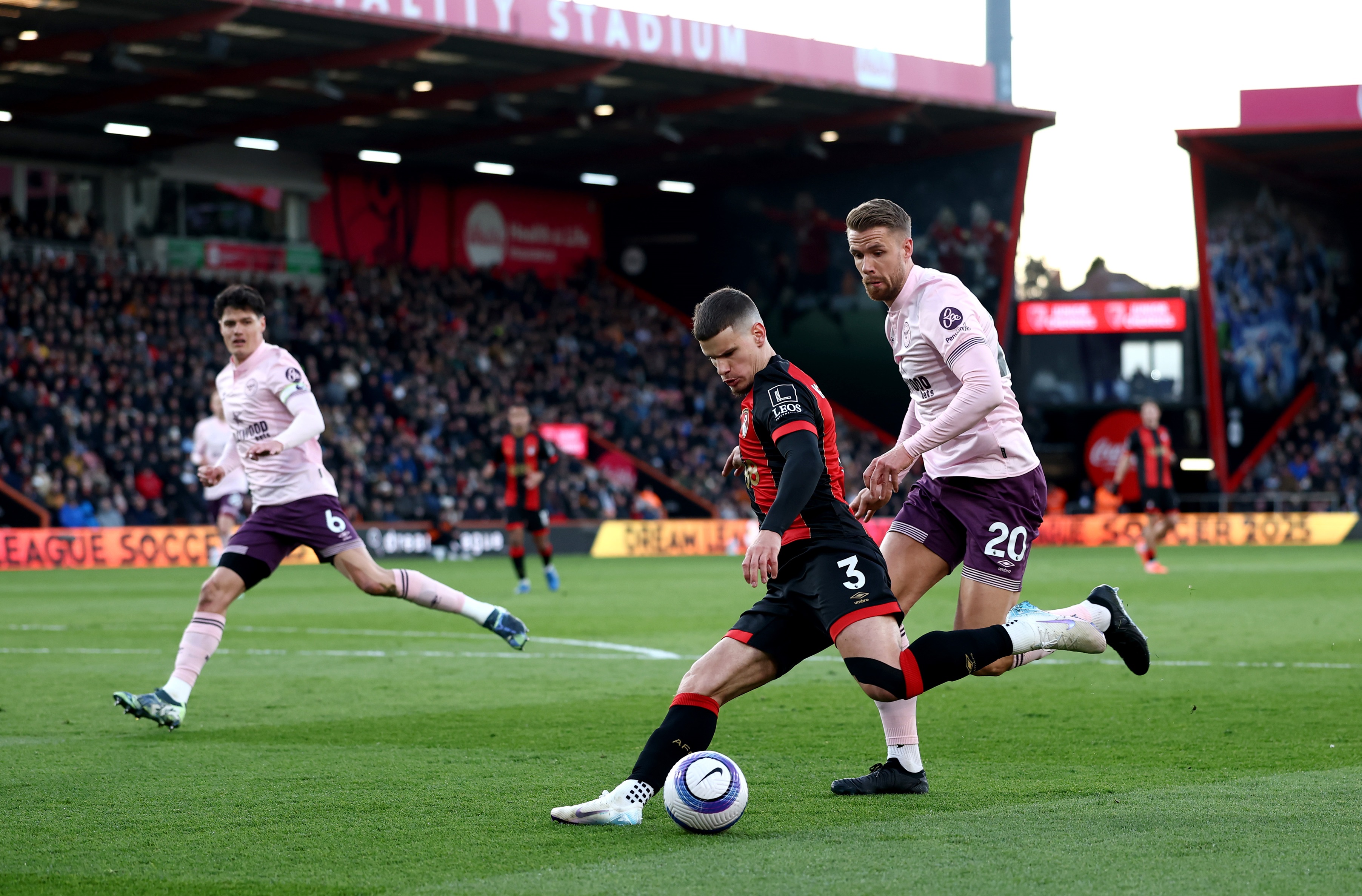 Milos Kerkez crosses the ball whilst under pressure.