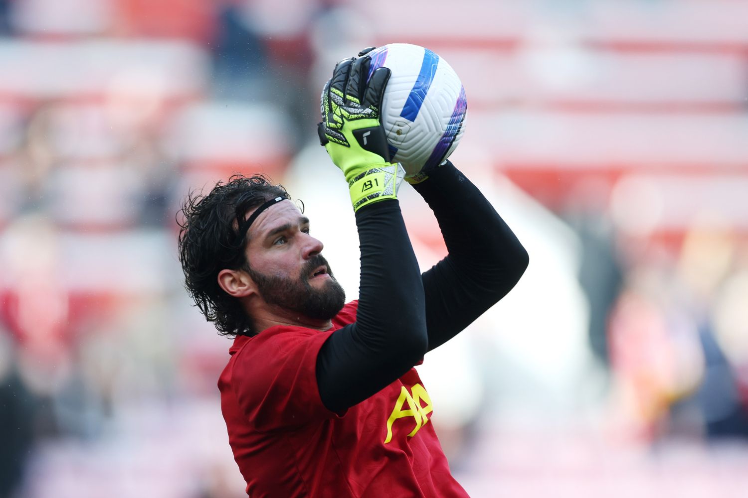 Alisson Becker warms up for Liverpool