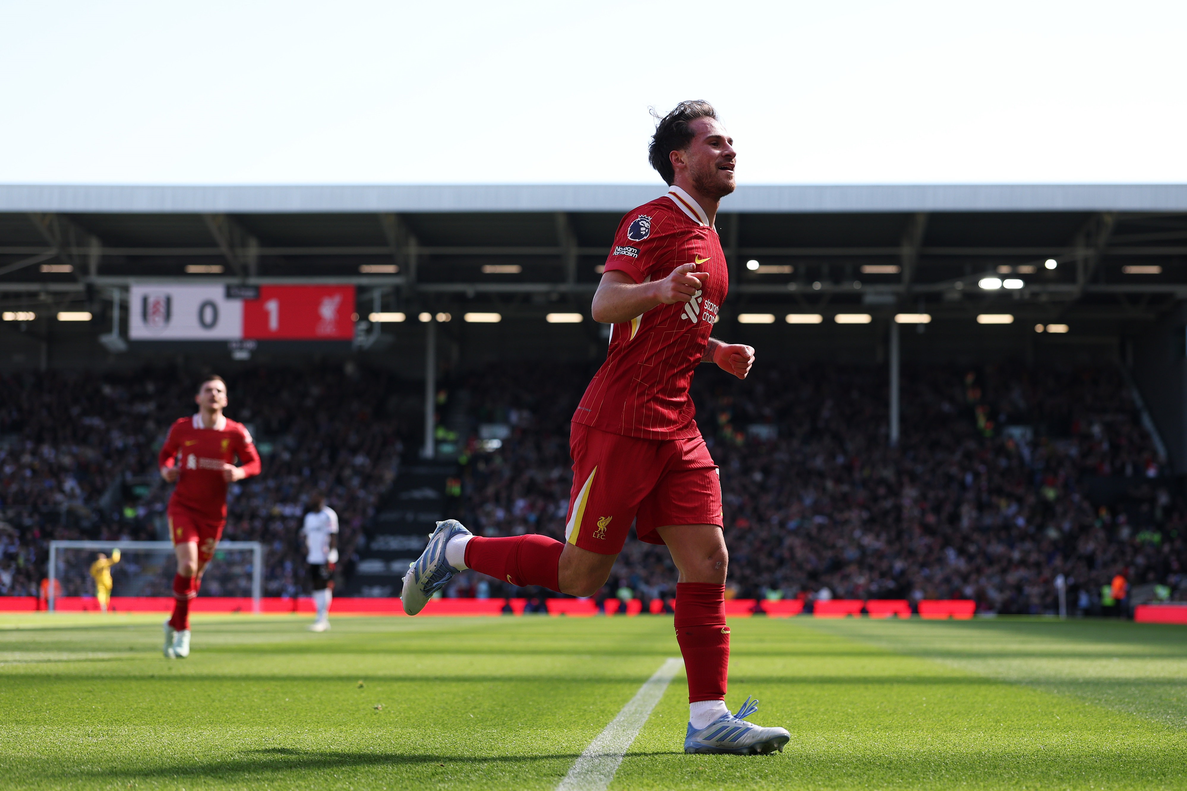 Alexis Mac Allister runs away in celebration after scoring a goal.