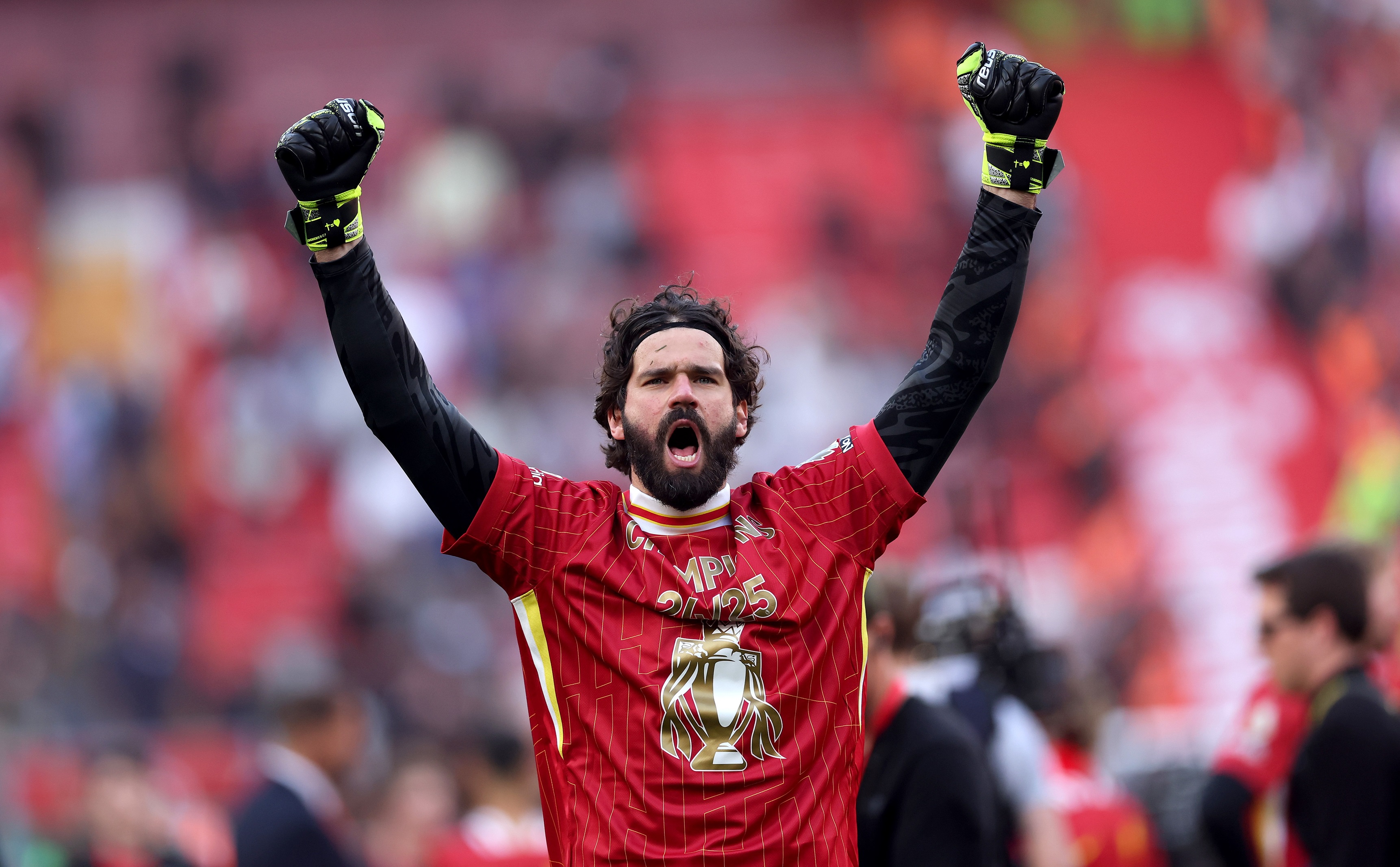 Alisson Becker pumps his arms celebrating Liverpool Premier League title.