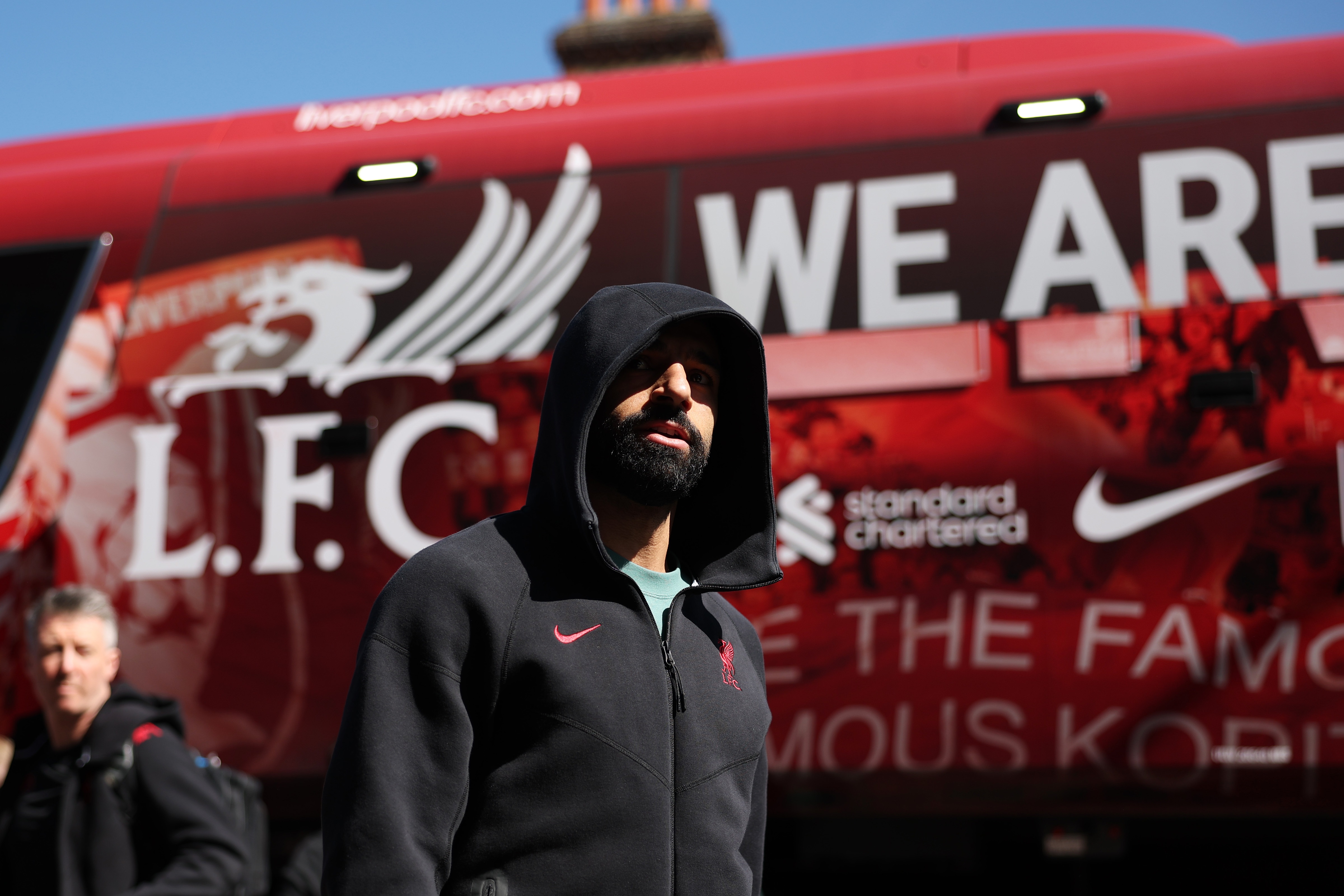 Mo Salah walks away from the Liverpool bus with his hood up.
