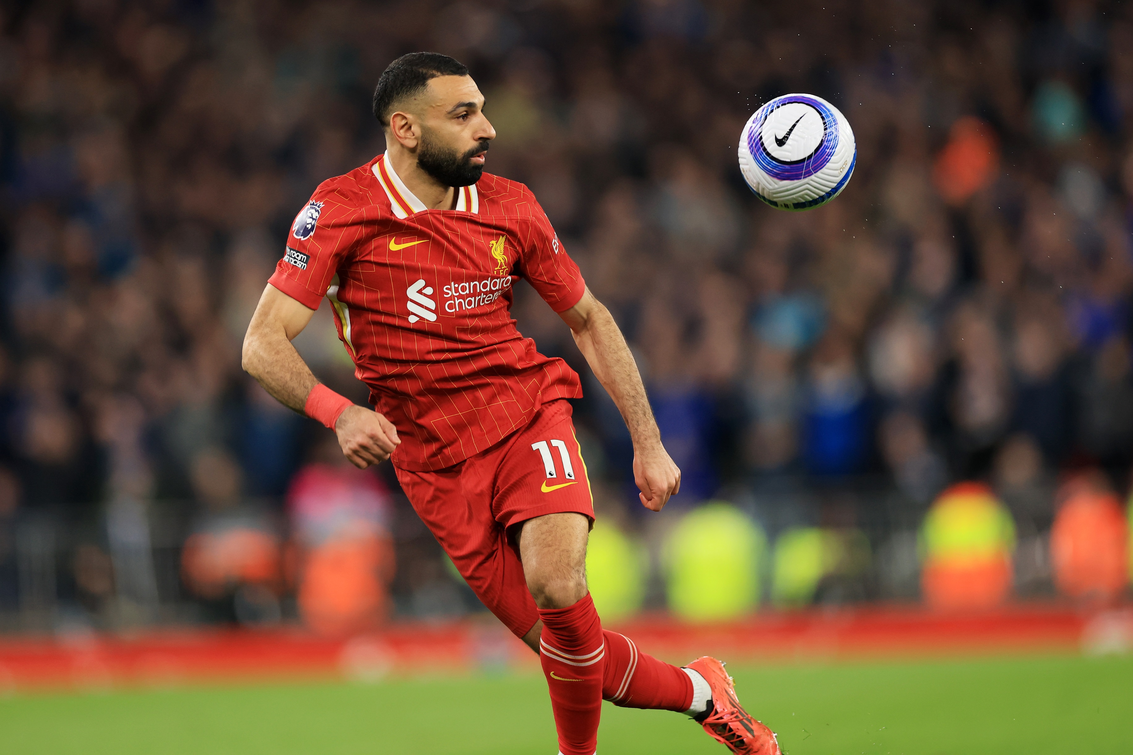 Mo Salah runs to catch a ball in mid-air.