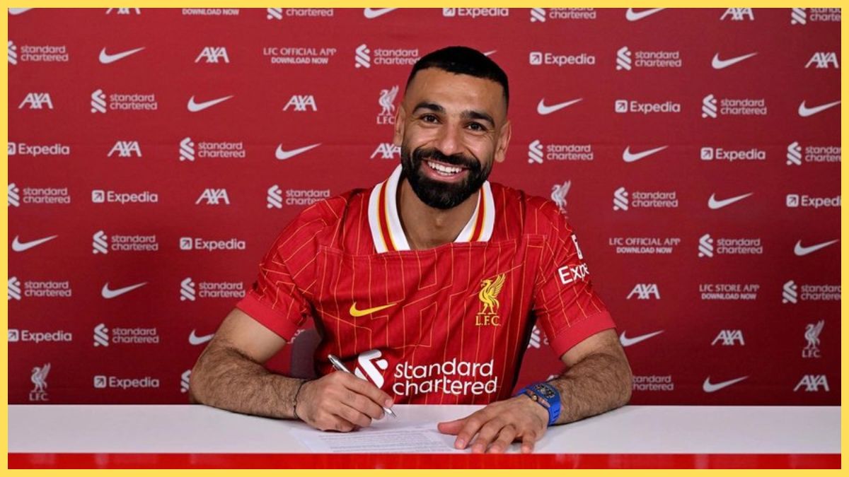 Mo Salah smiles whilst signing a contract extension.