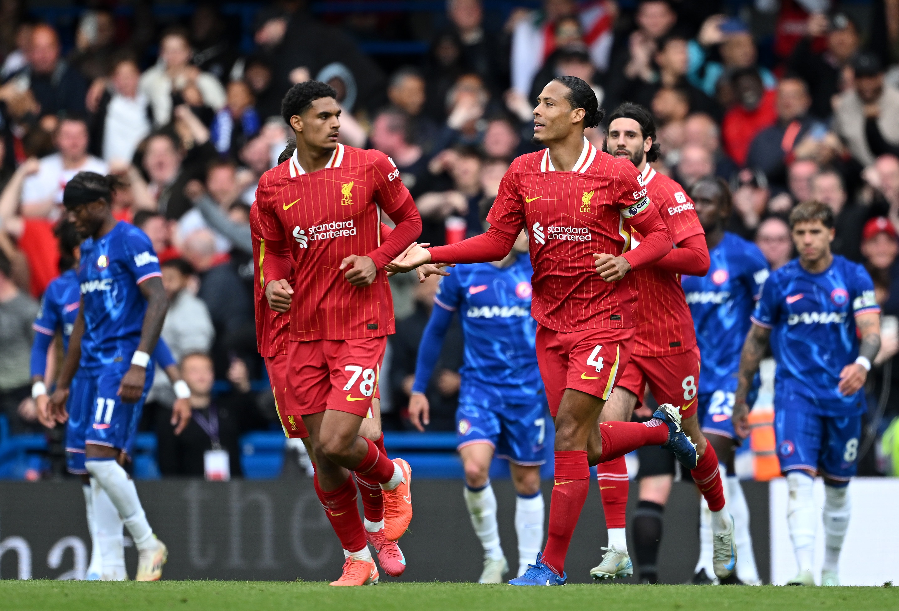 Jarell Quansah looks at Virgil van Dijk whilst running at Stamford Bridge.