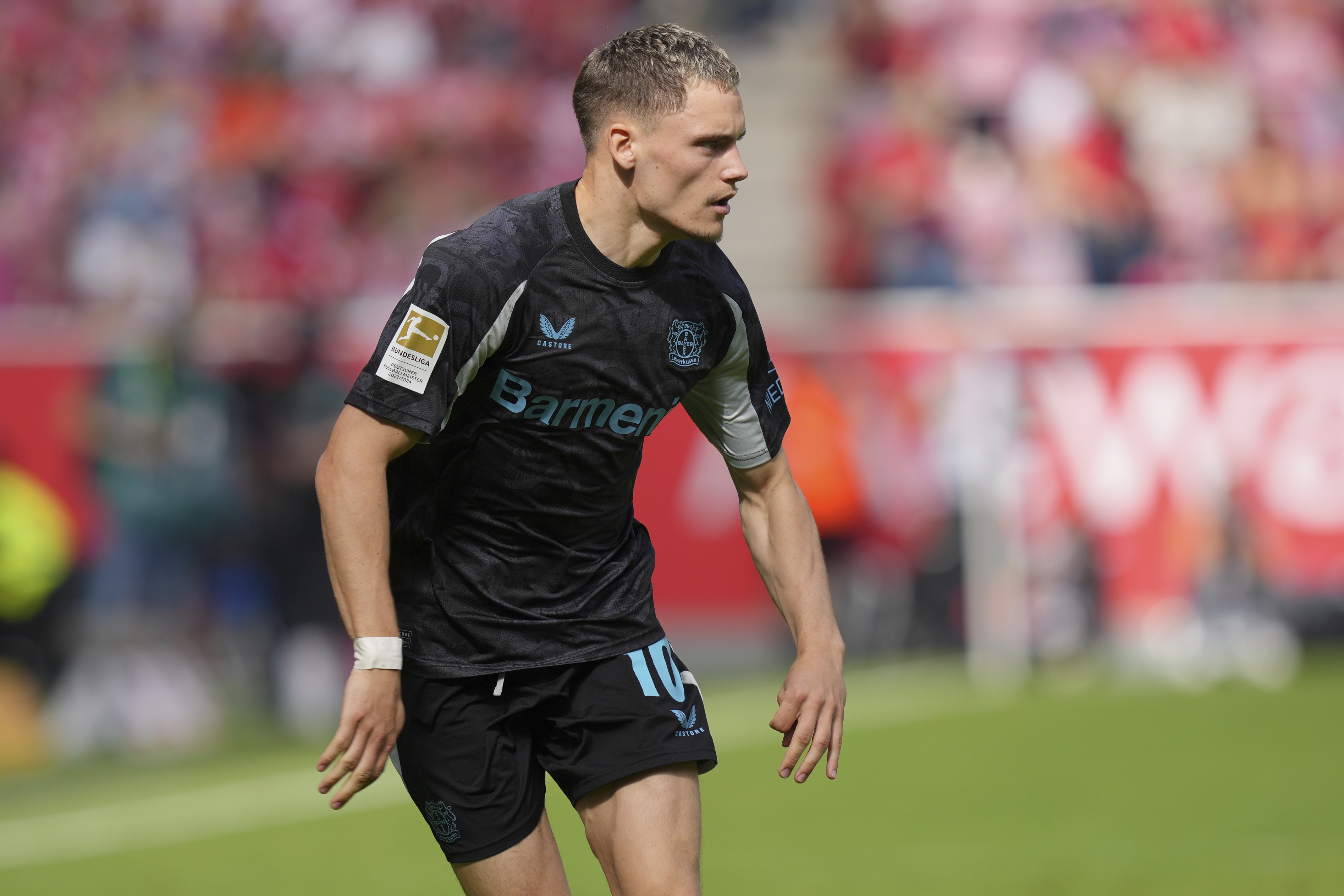 Florian Wirtz runs on the pitch during Bundesliga game.