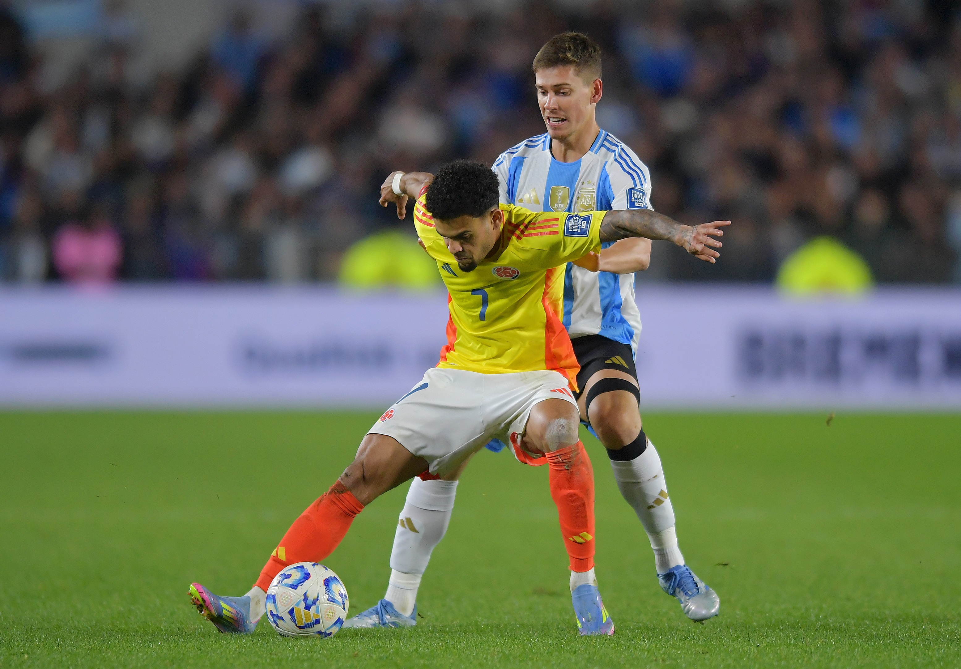 Luis Diaz holds off Juan Foyth from the ball.