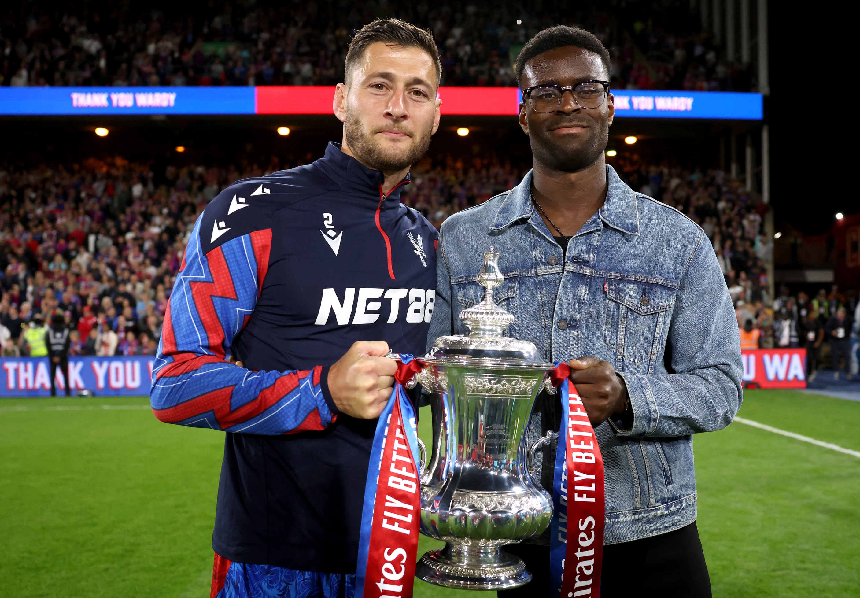 Marc Guehi holds the FA Cup trophy with Joel Ward.