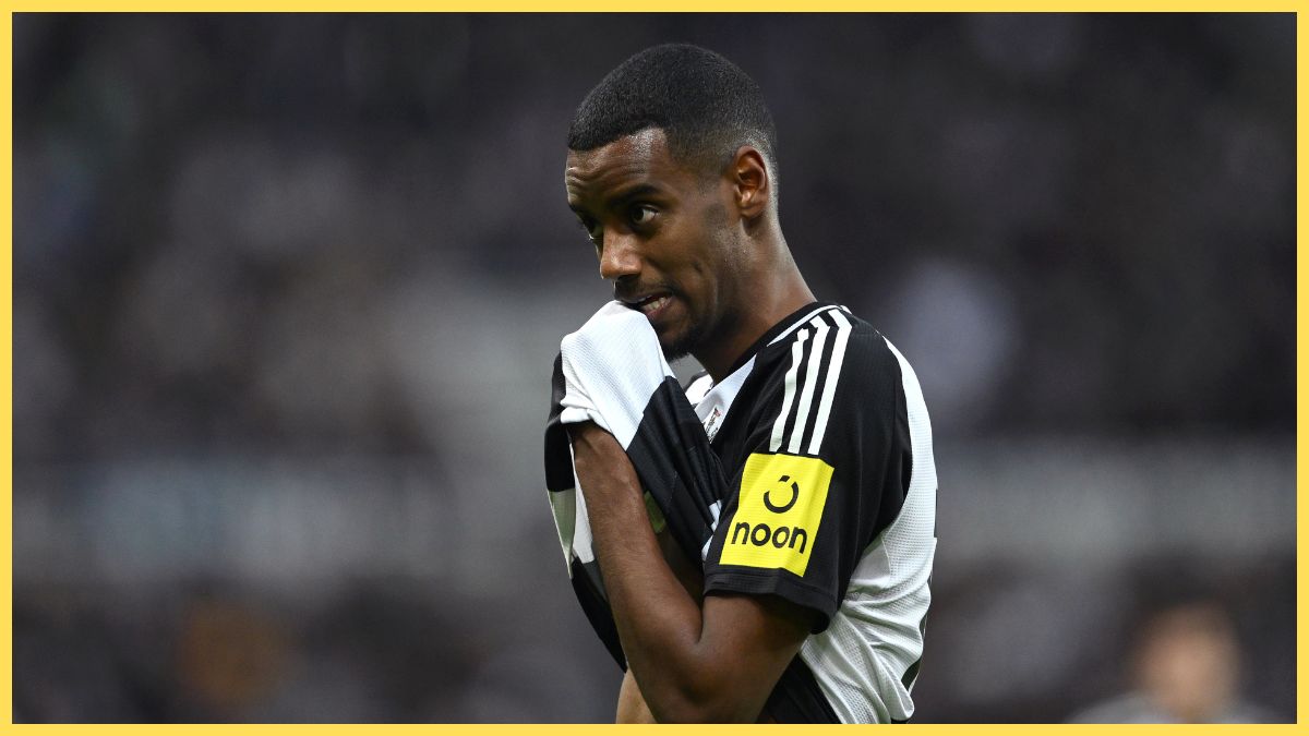 Alexander Isak wipes his chin with the bottom of his Newcastle shirt.