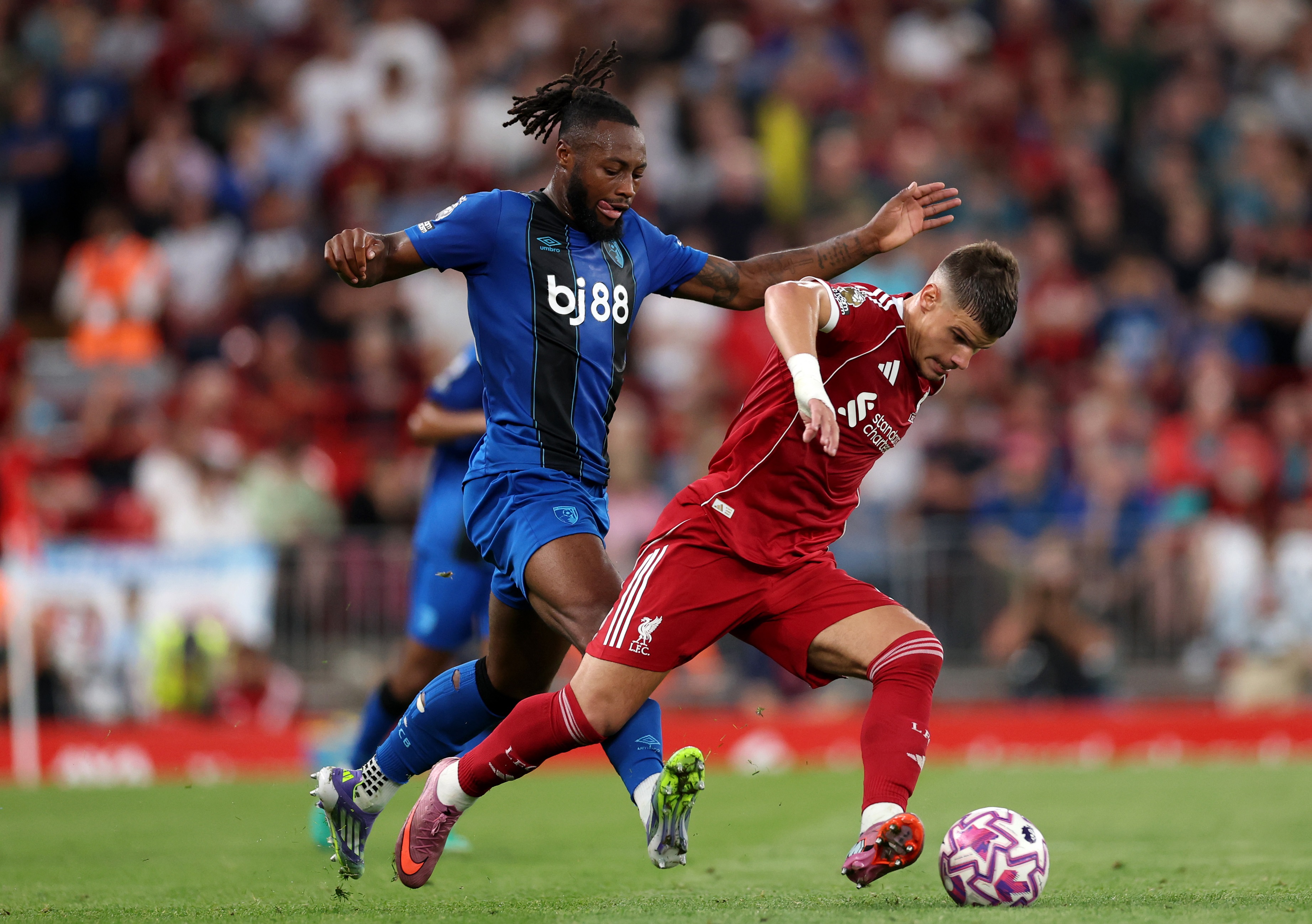 Antoine Semenyo puts pressure on Milos Kerkez who dribbles with the ball.