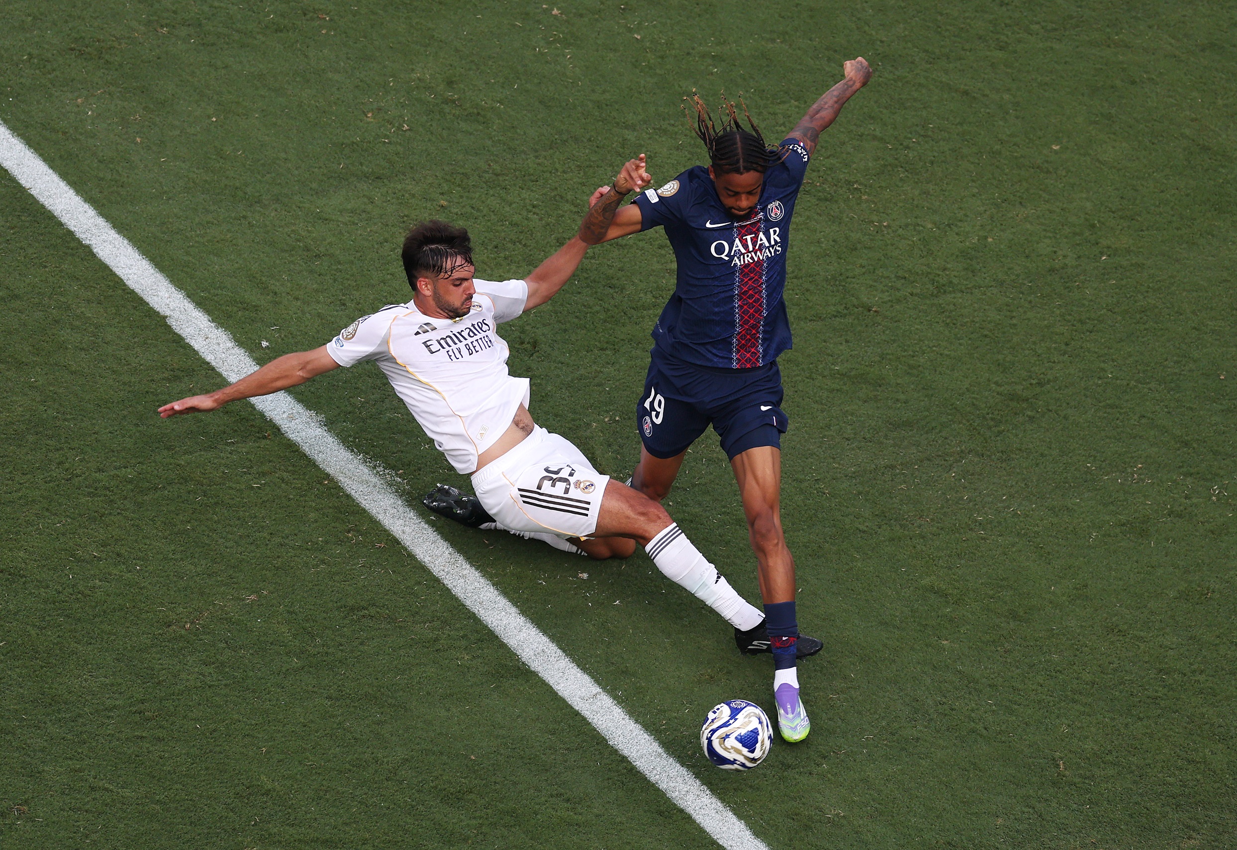 Bradley Barcola dribbles away from Marco Asencio after Real Madrid star goes to ground.