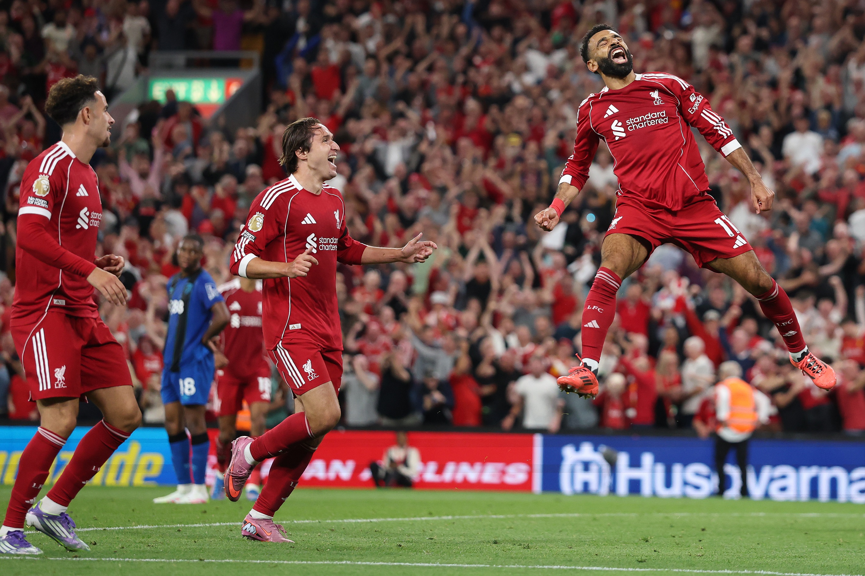 Federico Chiesa grins as Mo Salah jumps in the air to celebrate.