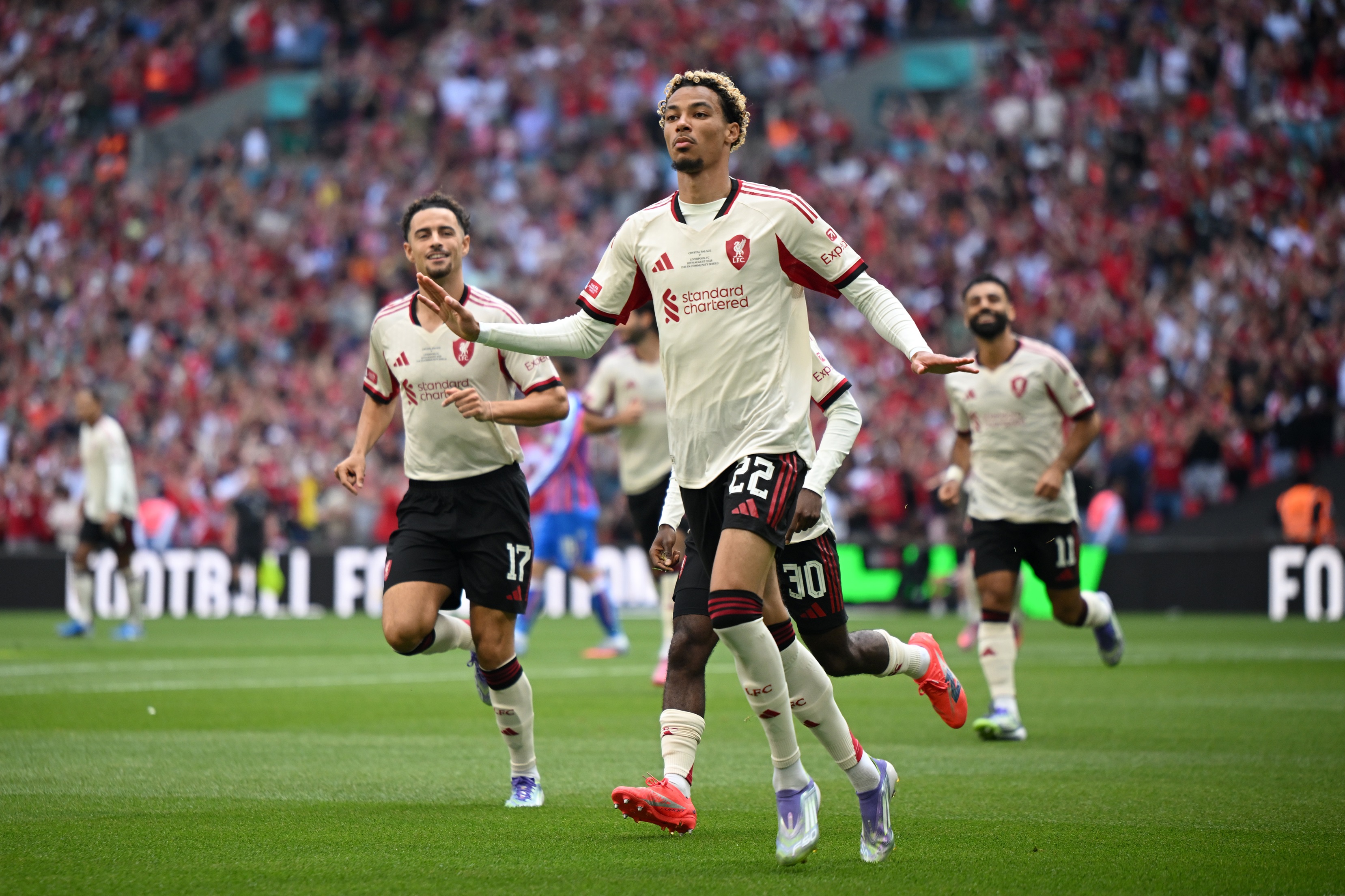 Hugo Ekitike holds out his arms whilst running.