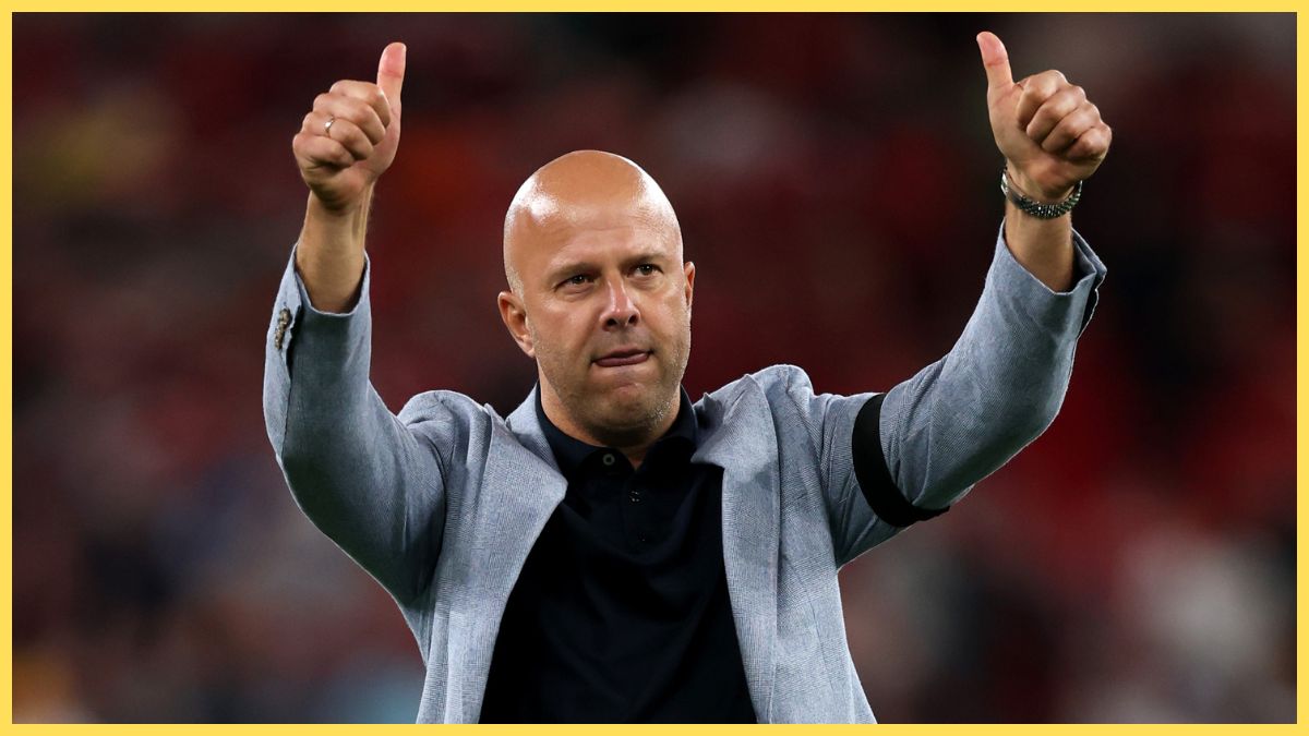 Arne Slot holds up two thumbs up at Anfield stadium.