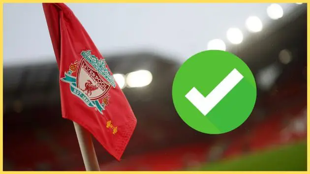 Liverpool flag flaps in the wind next to green check mark.