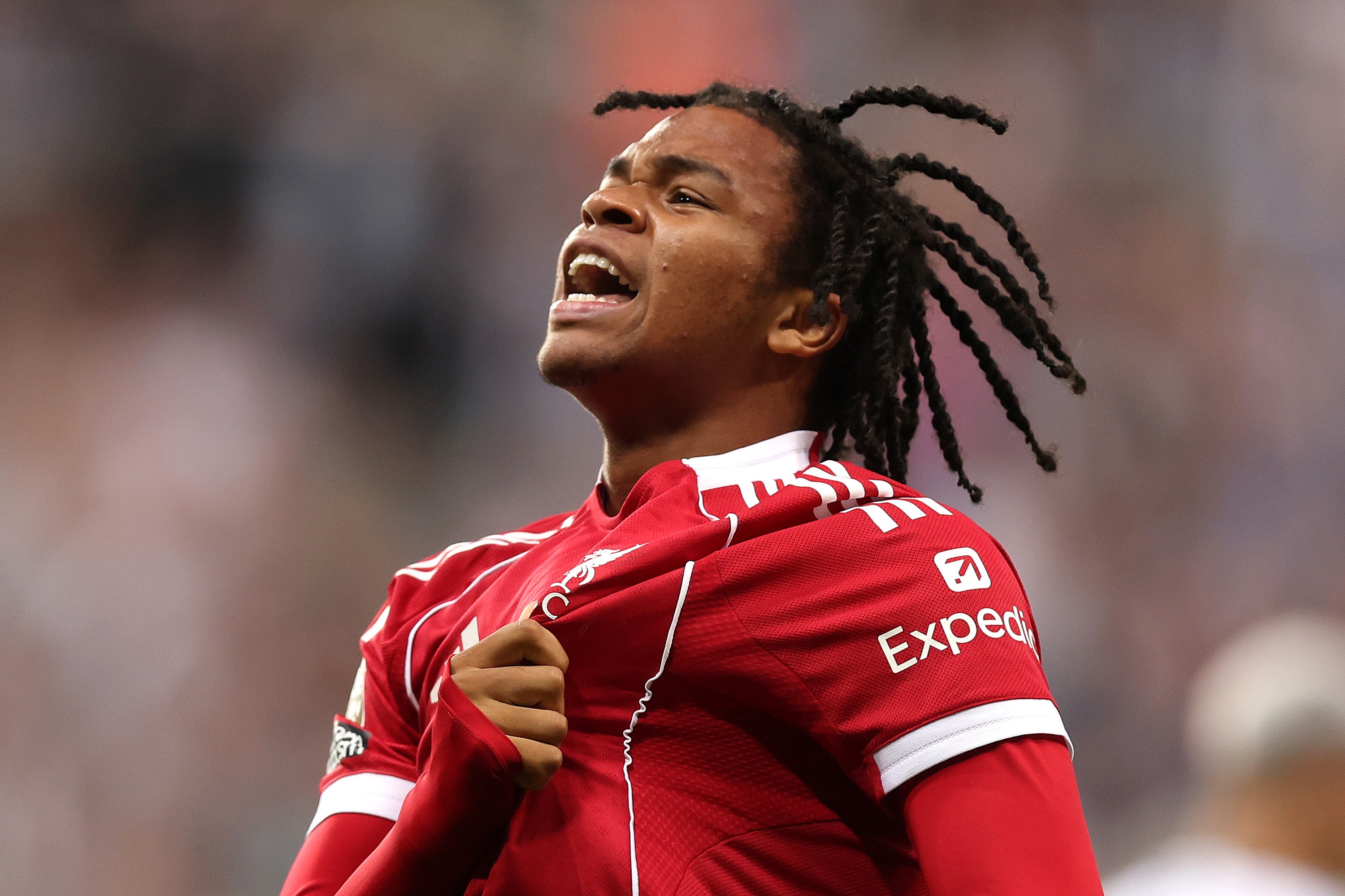 Rio Ngumoha grabs the liverbird crest on his Liverpool shirt.