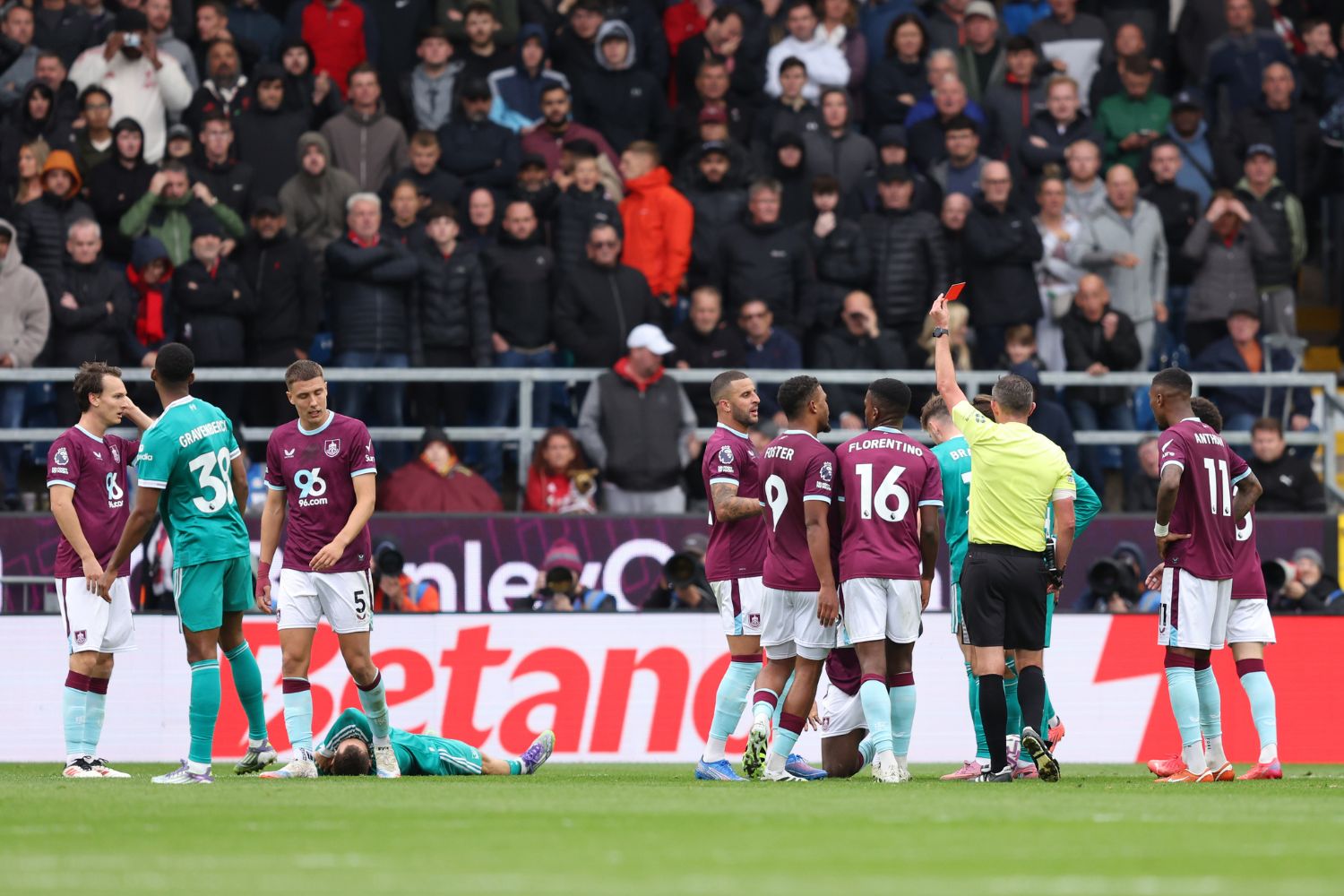 Referee Michael Oliver is shows a red card to Lesley Ugochukwu of Burnley