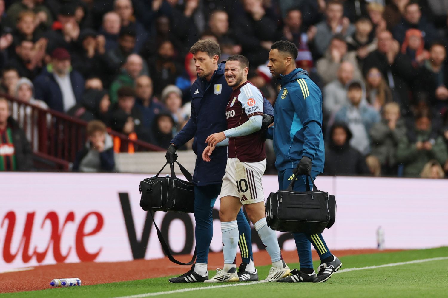 Emiliano Buendia of Aston Villa leaves the pitch after receiving medical treatment