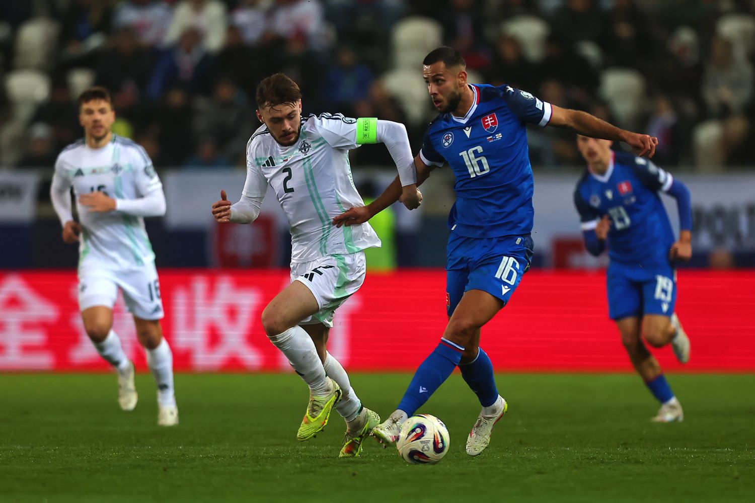 Conor Bradley of Northern Ireland challenges David Hancko of Slovakia