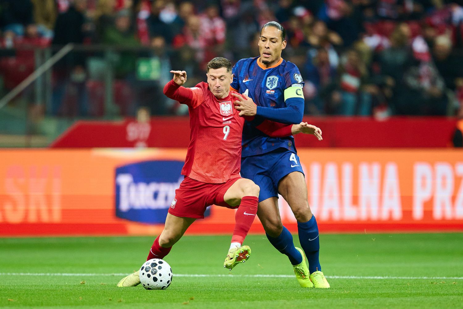 Robert Lewandowski of Poland and Virgil van Dijk of Netherlands fight for the ball