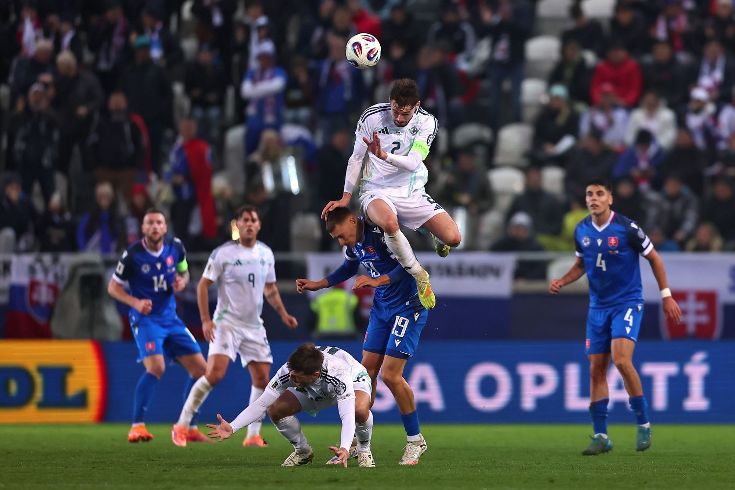 Conor Bradley of Northern Ireland jumps for the ball against Tomas Rigo of Slovakia