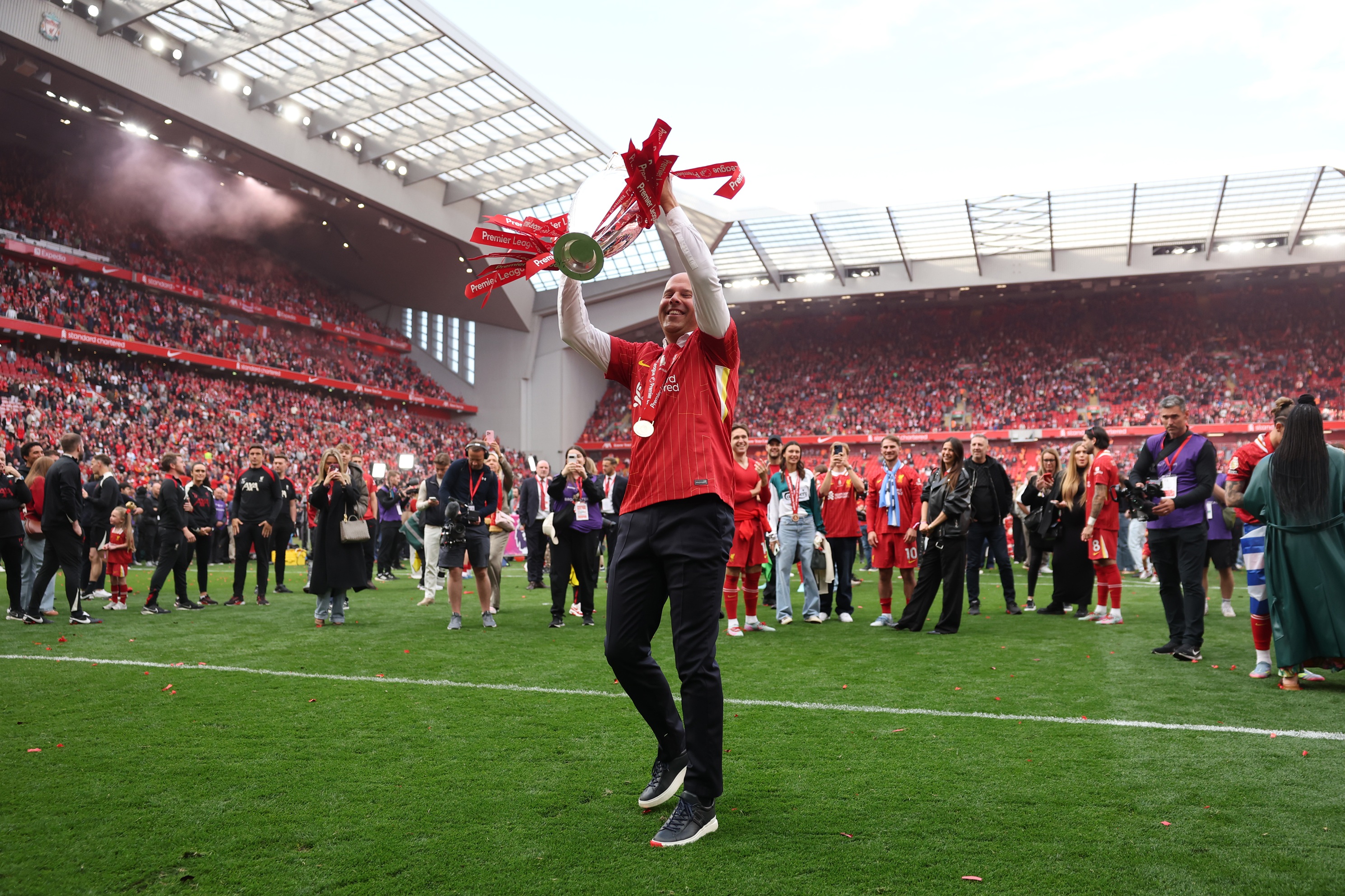 Liverpool head coach Arne Slot lifts up the Premier League trophy inside Anfield.
