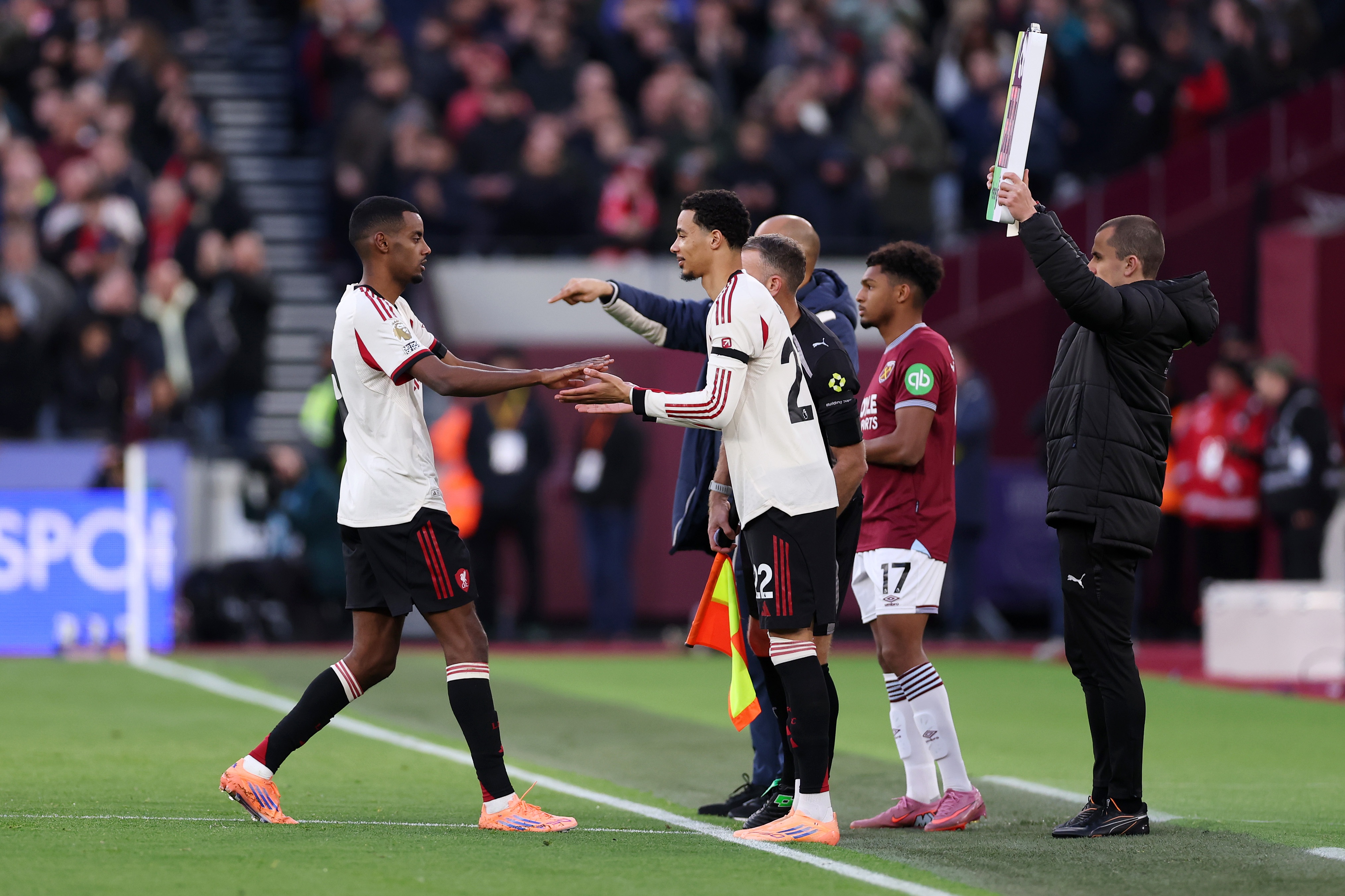 Alexander Isak high fives Hugo Ekitike on the touchline.