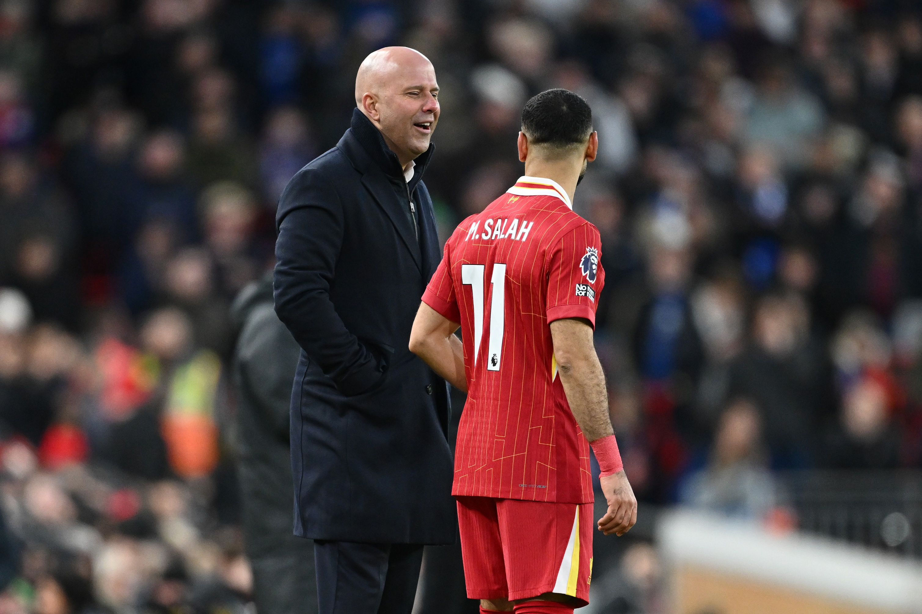 Arne Slot talks with Mo Salah on the touchline.