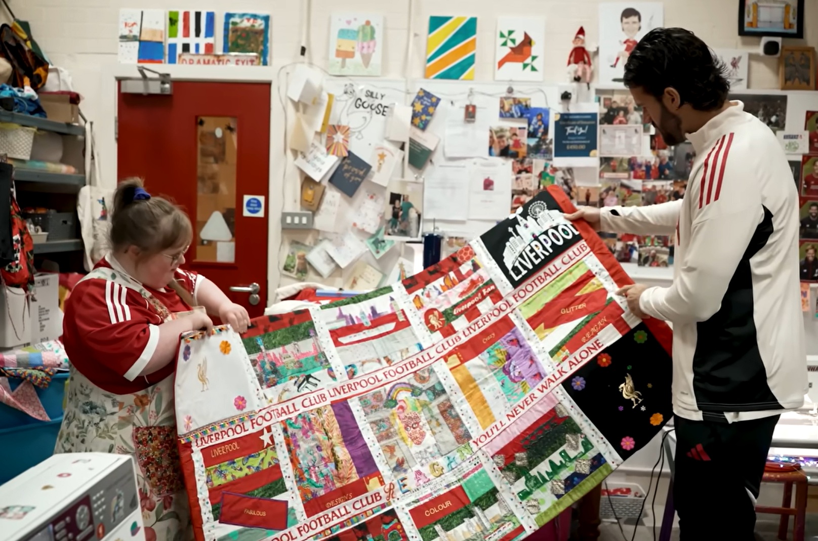 Reagan shows Alisson her handmade Liverpool banner, which was flown on the Kop when the Reds played Sunderland at Anfield