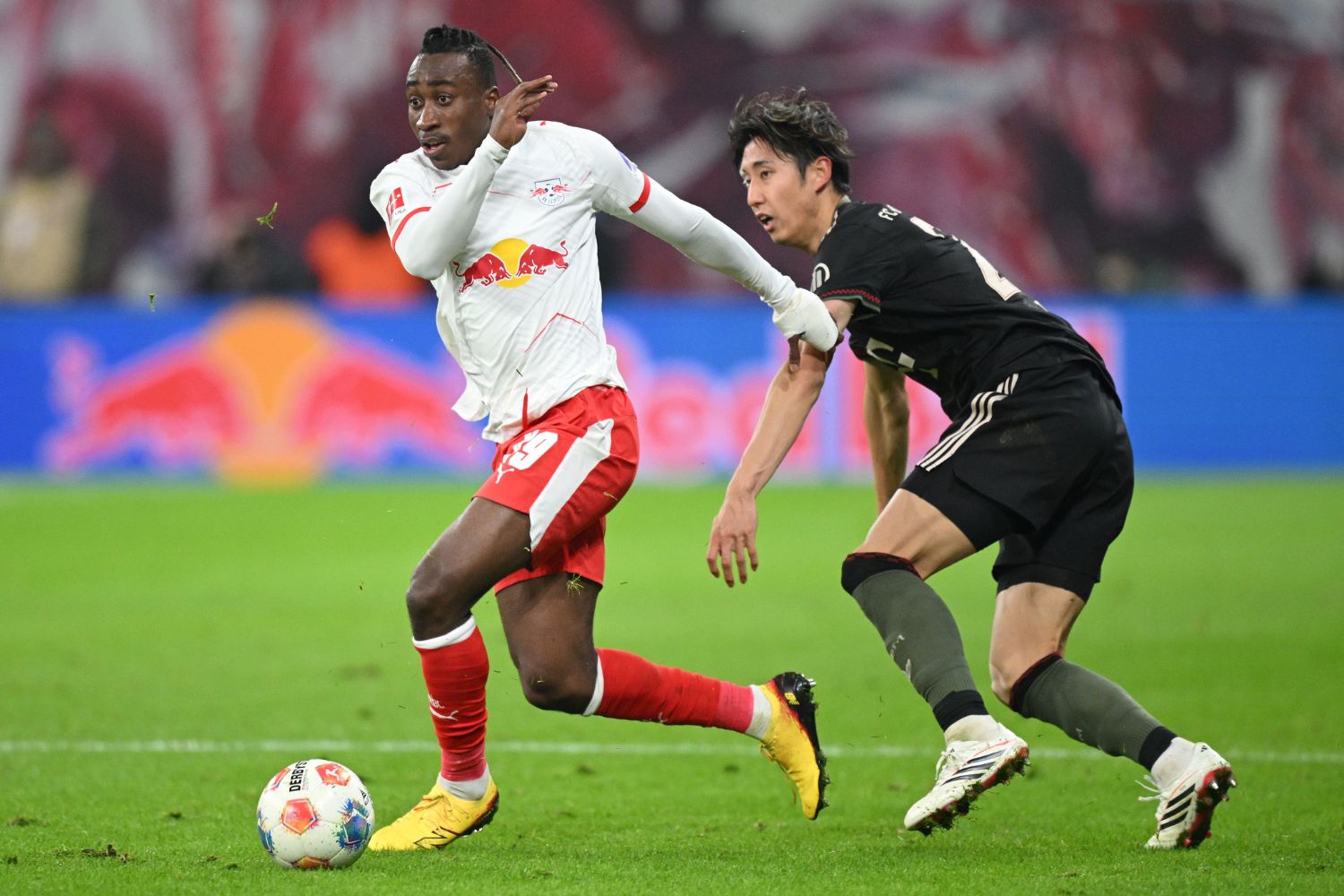 Yan Diomande of RB Leipzig is challenged by Hiroki Ito of FC Bayern Munich