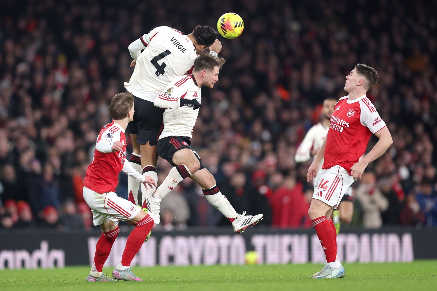 Virgil van Dijk of Liverpool jumps for the ball with teammate Alexis Mac Allister