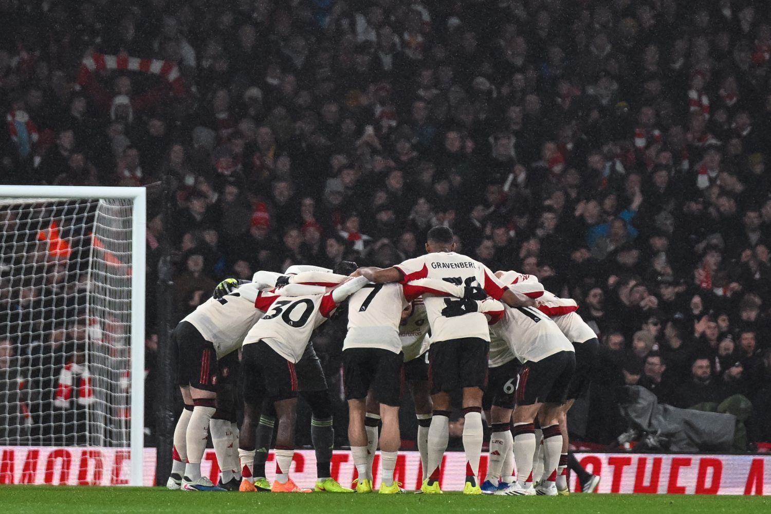 Liverpool squad in a team huddle before playing Arsenal
