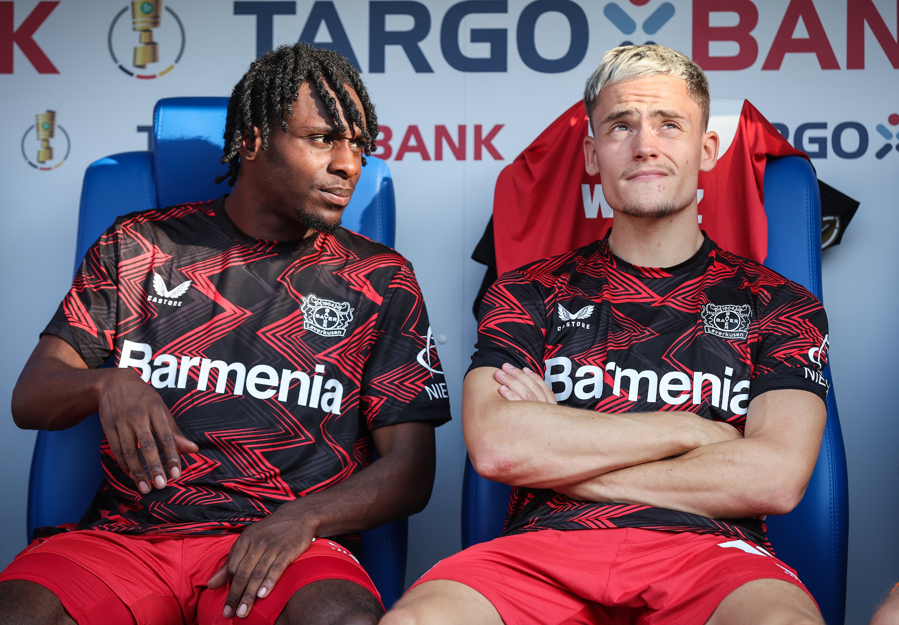 Jeremie Frimpong looks at Florian Wirtz on the bench.