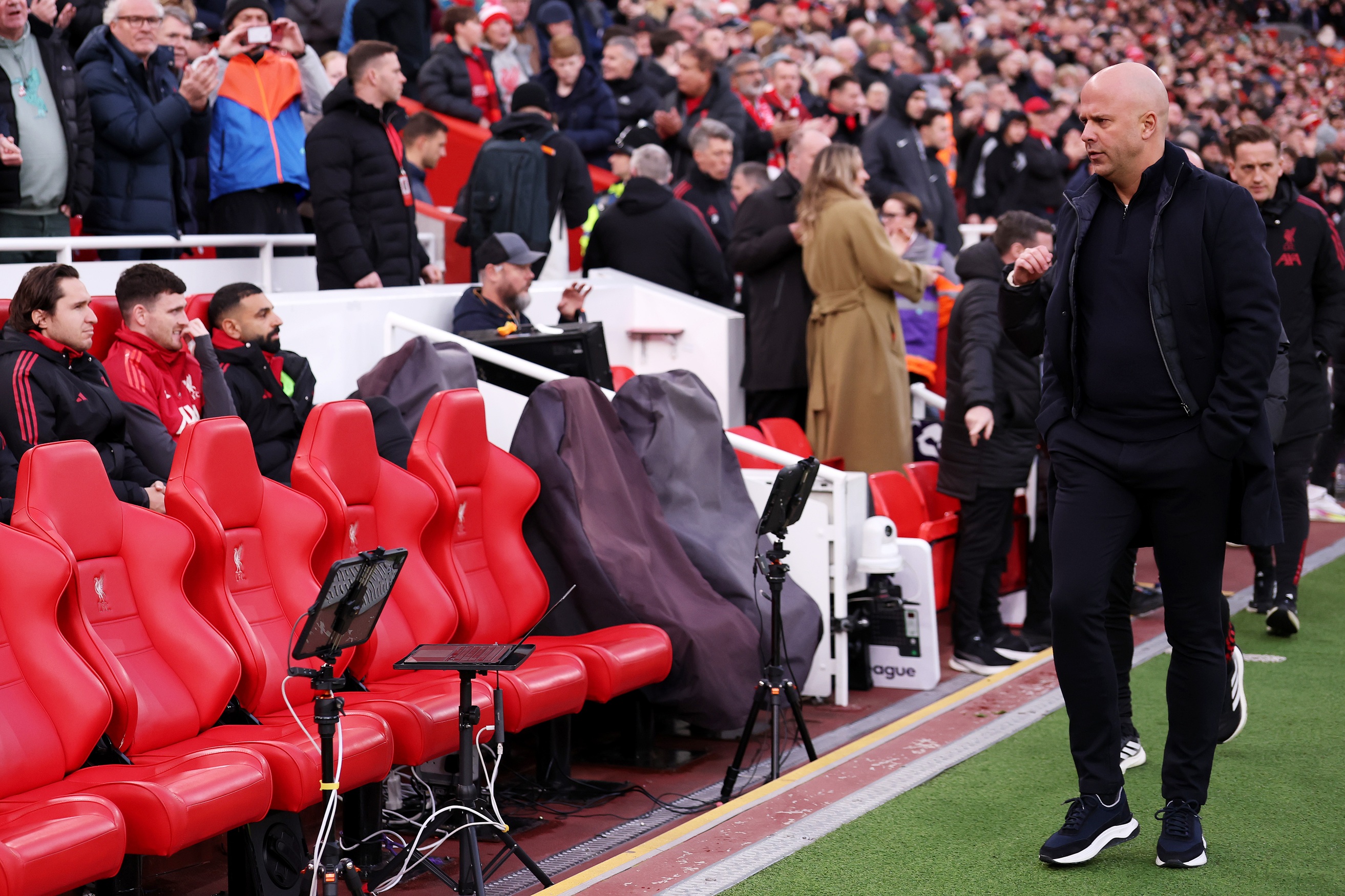 Arne Slot looks at his Liverpool bench where Mo Salah is sat.