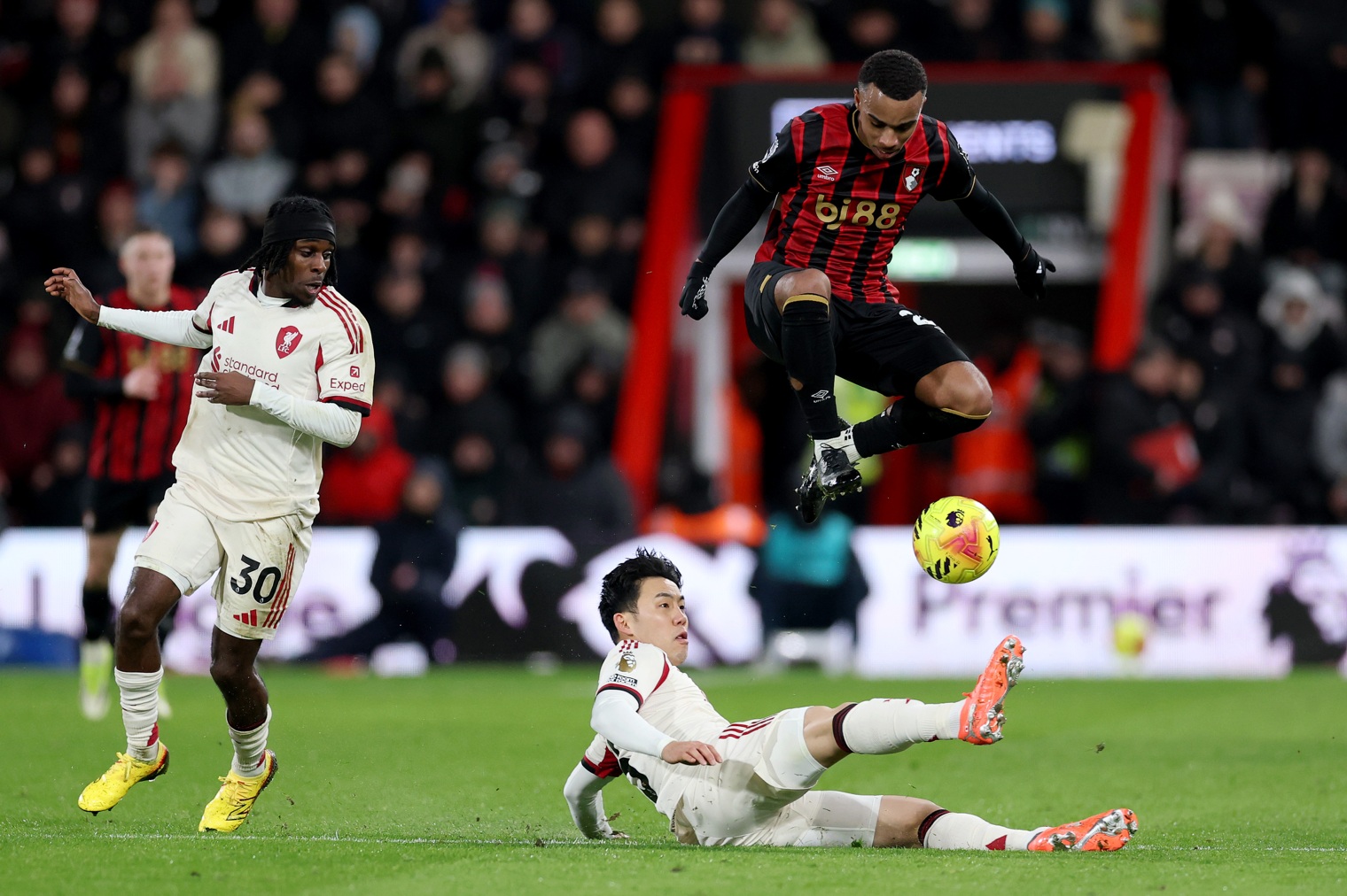Eli Junior Kroupi of AFC Bournemouth is challenged by Wataru Endo of Liverpool