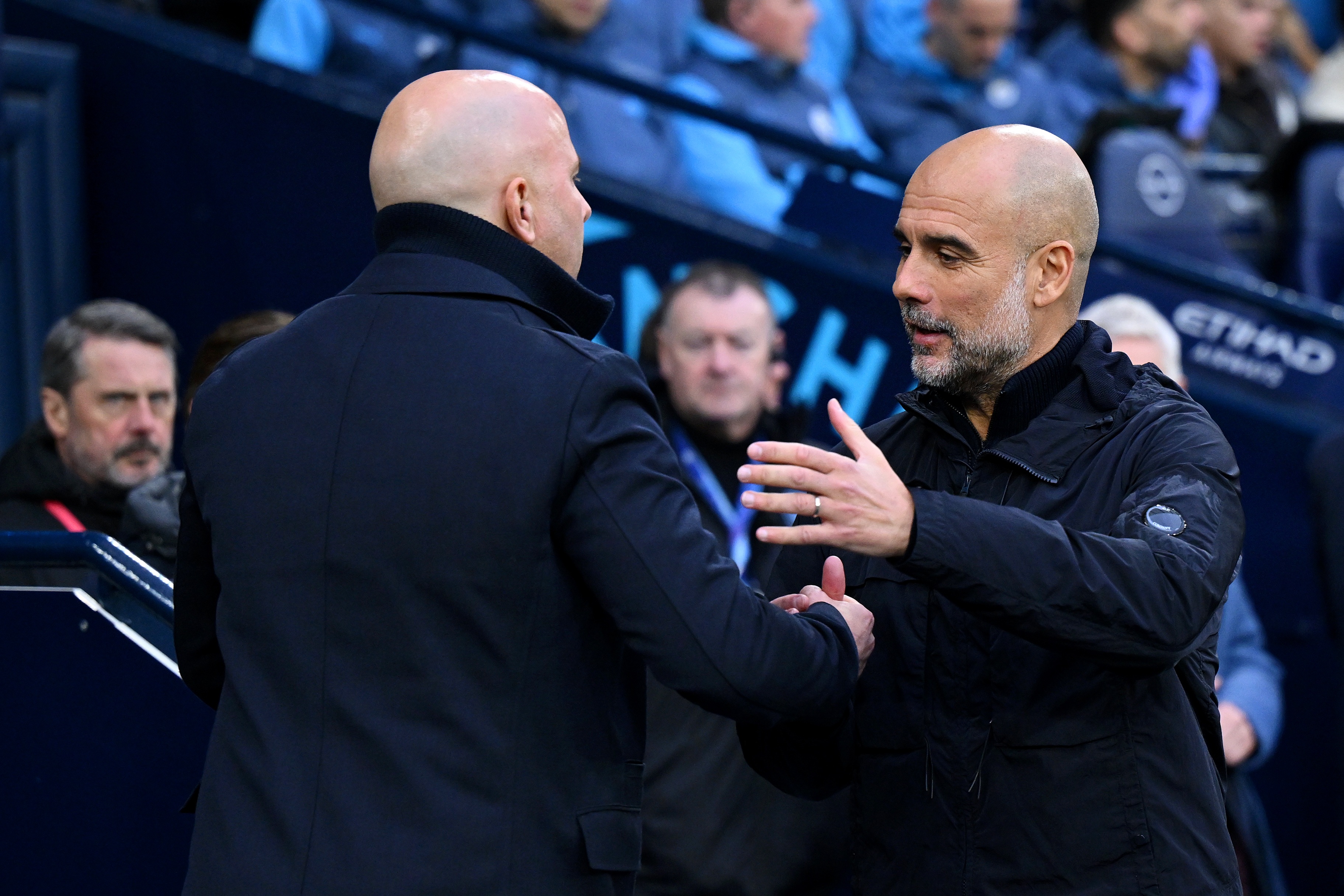 Pep Guardiola hugs Liverpool head coach Arne Slot.