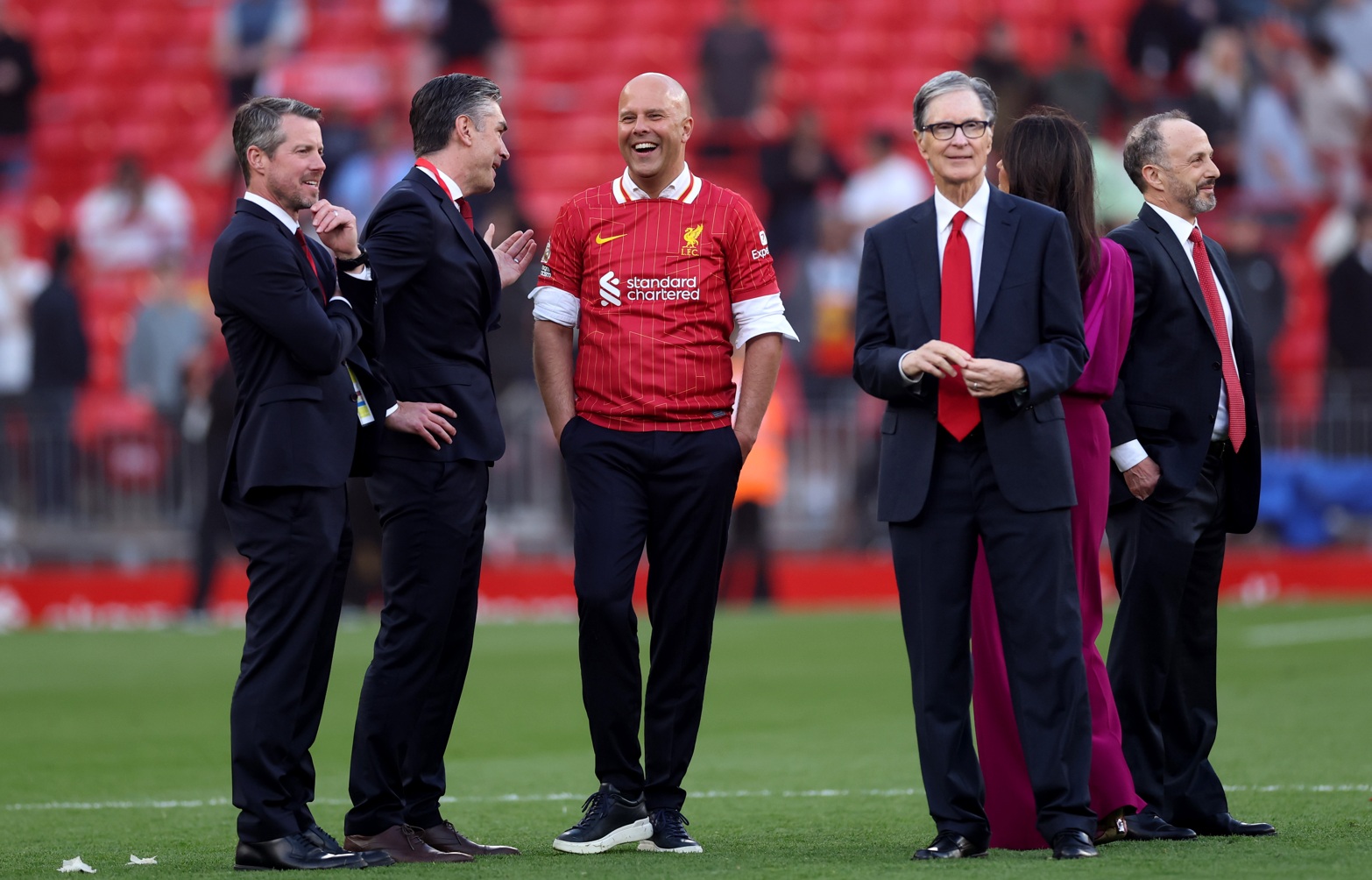 Richard Hughes and Arne Slot share a laugh on the pitch at Anfield after Liverpool won the Premier League last year