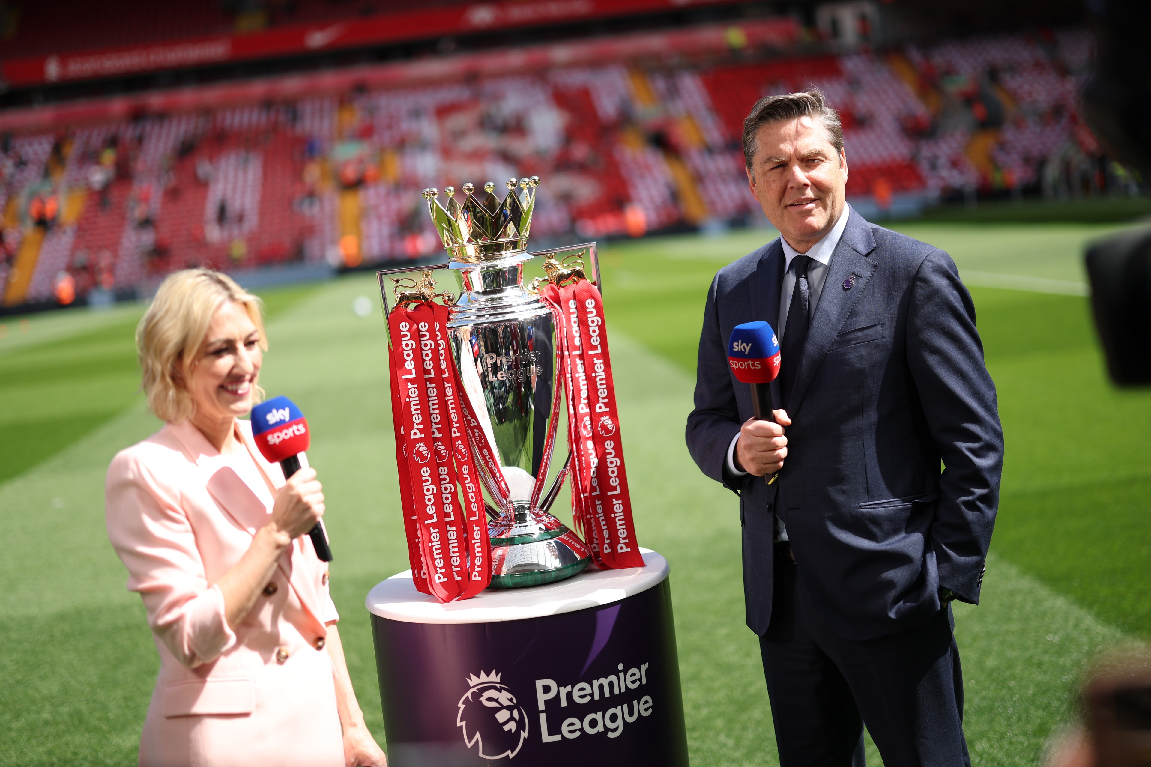 Kelly Cates speaks with Richard Masters next to the Premier League trophy.