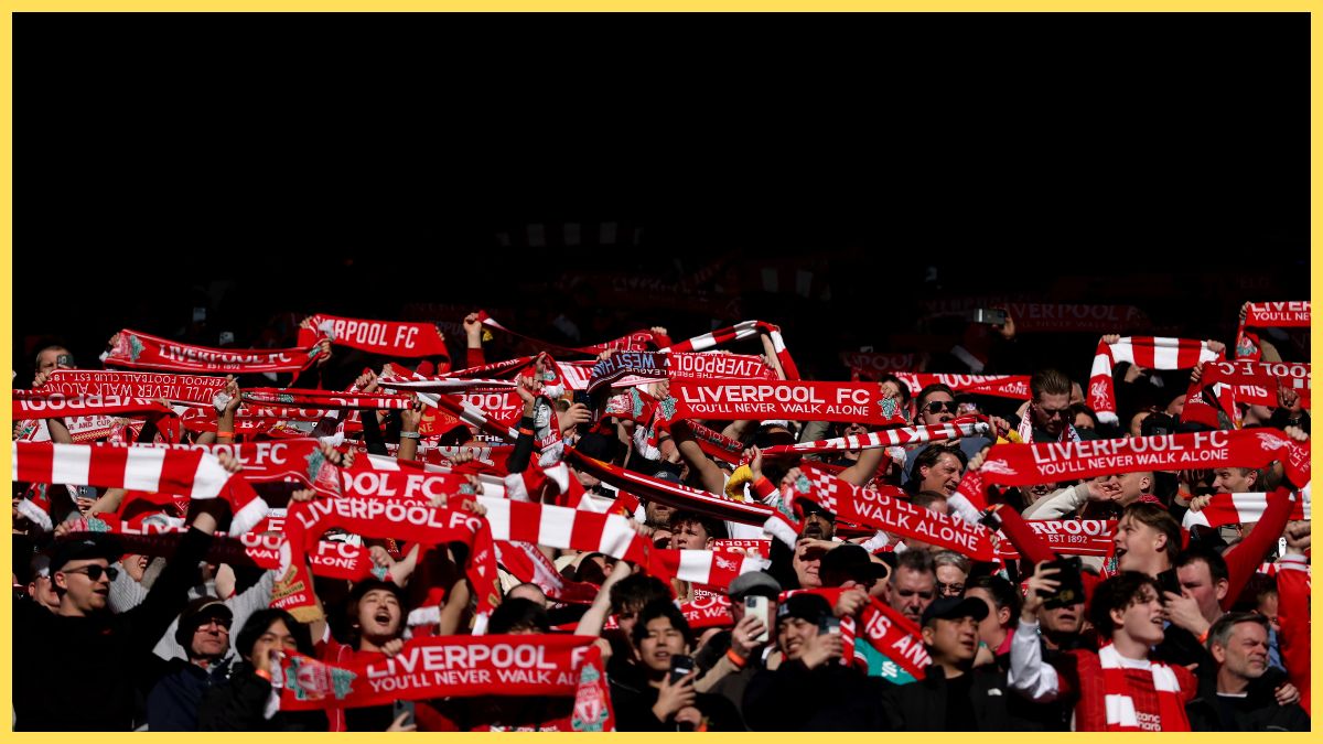 Fans of Liverpool hold their scarves aloft prior to the Premier League match between Liverpool and West Ham United at Anfield