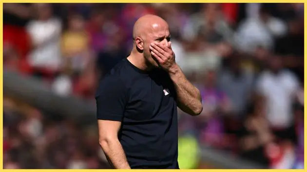 Arne Slot covers his mouth with his hand during Liverpool game.