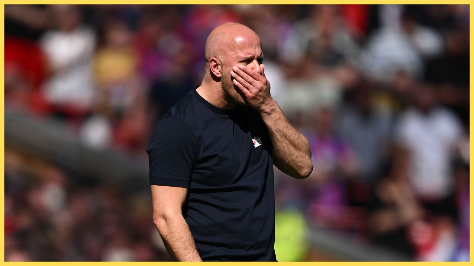 Arne Slot covers his mouth with his hand during Liverpool game.